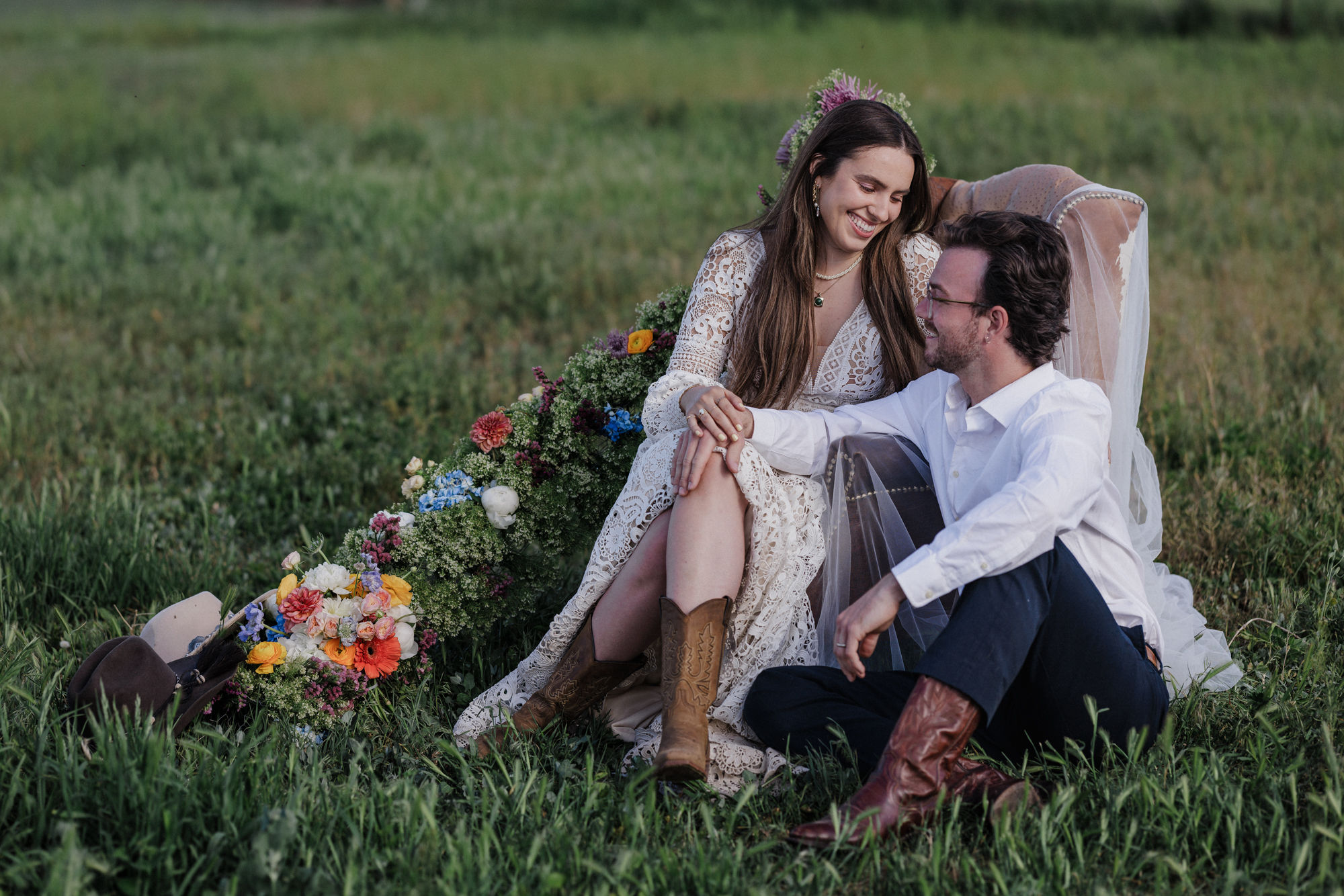 bride and groo sit in chair surrounded by flowers after finishing their elopement planning checklist