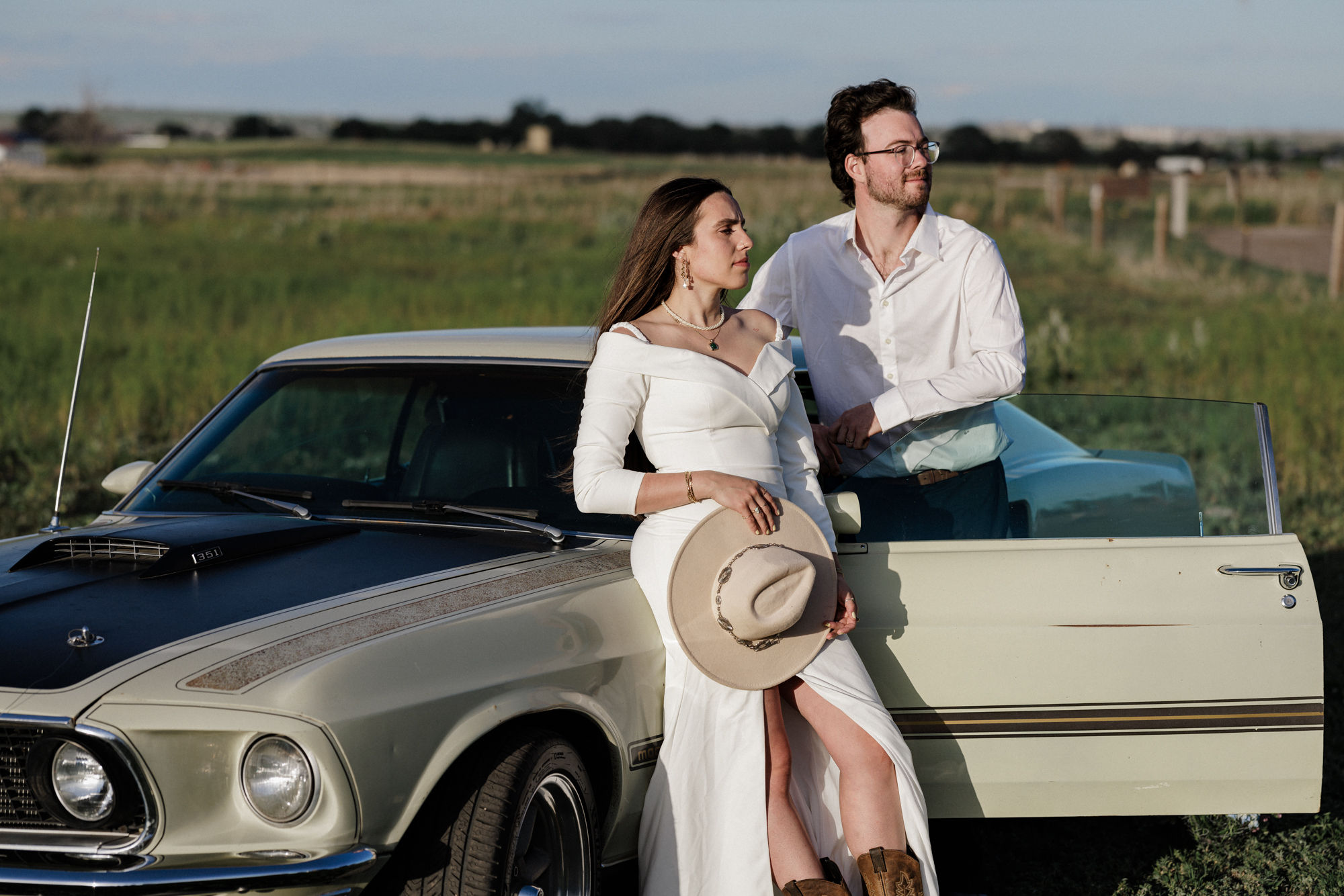 after involving their partner in wedding planning, bride and groom lean on vintage car for wedding photos