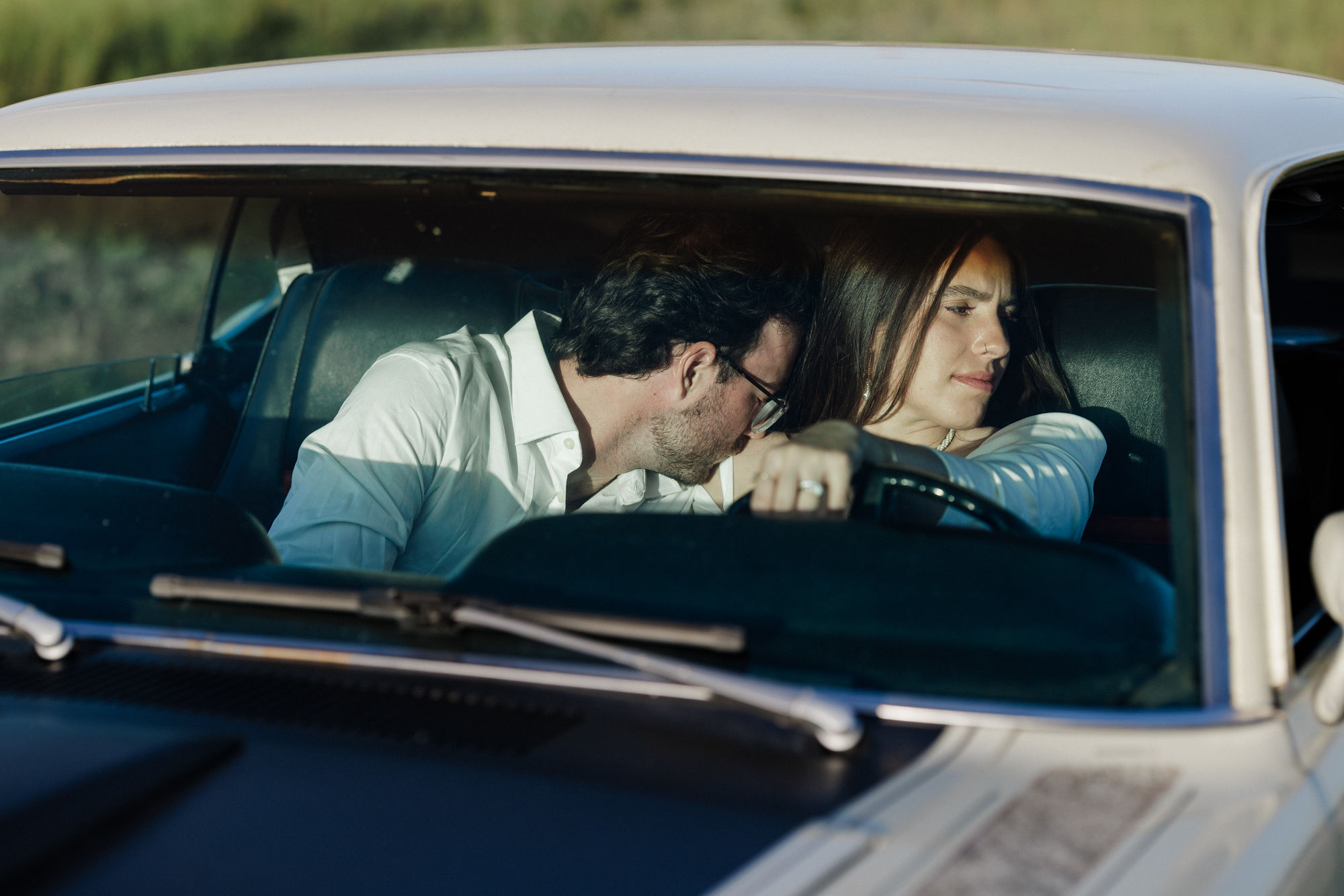 after finishing elopement planning checklist, bride and groom sit in vintage car for photos.