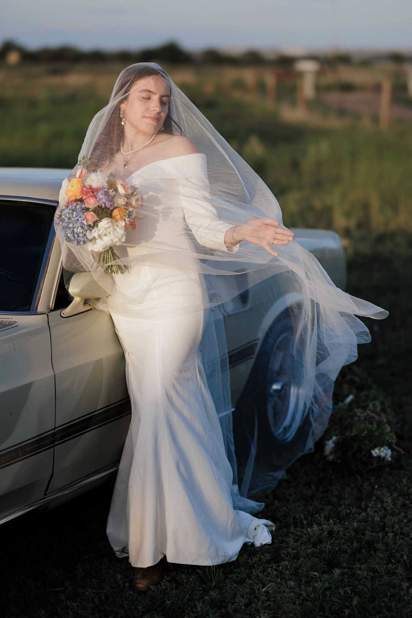 bride holds bouquet with veil over her face during bridal portraits