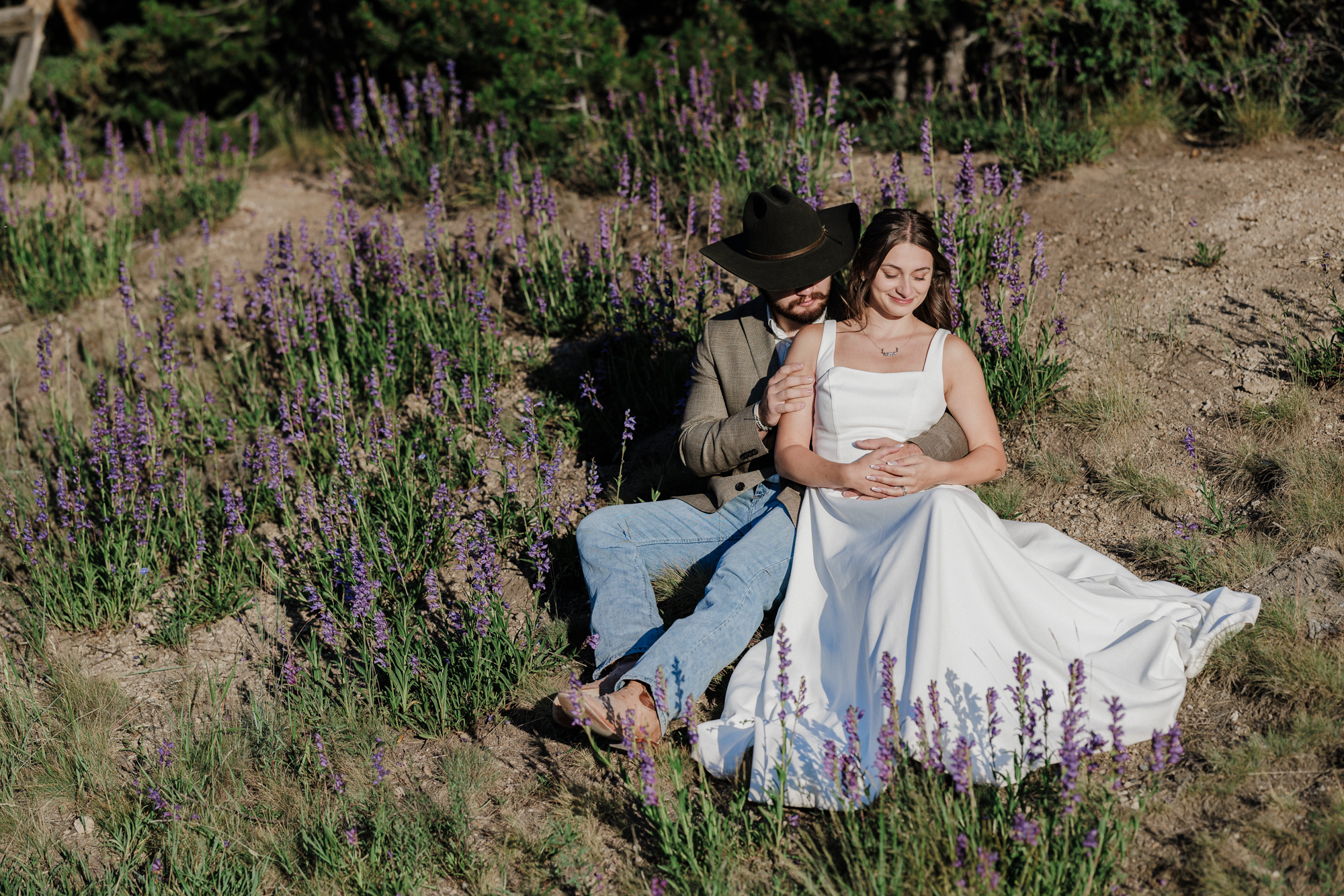 bride and groom hold one another among wildflowers during their Colorado mountain elopement.