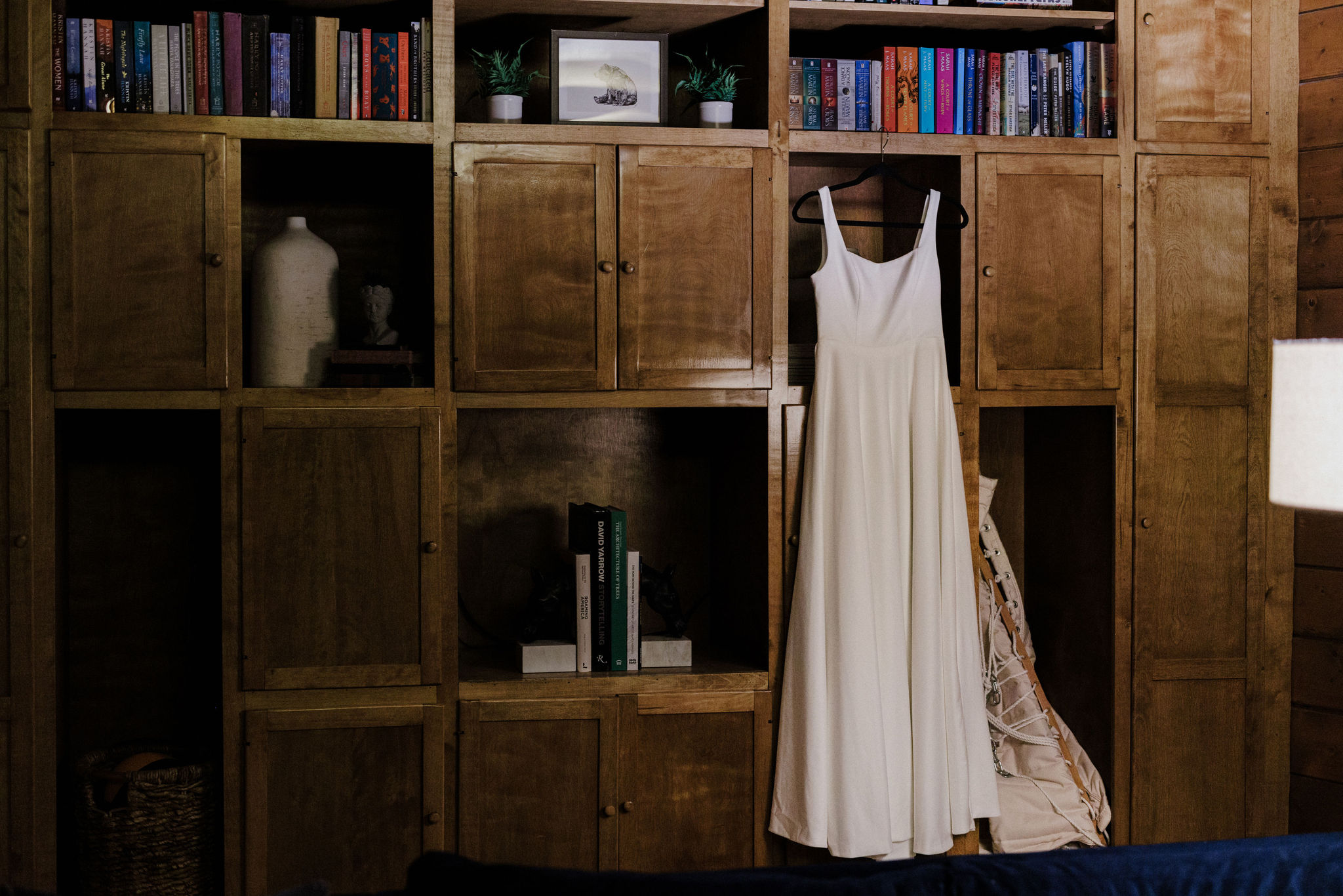 wedding dress hangs from bookshelf at colorado airbnb