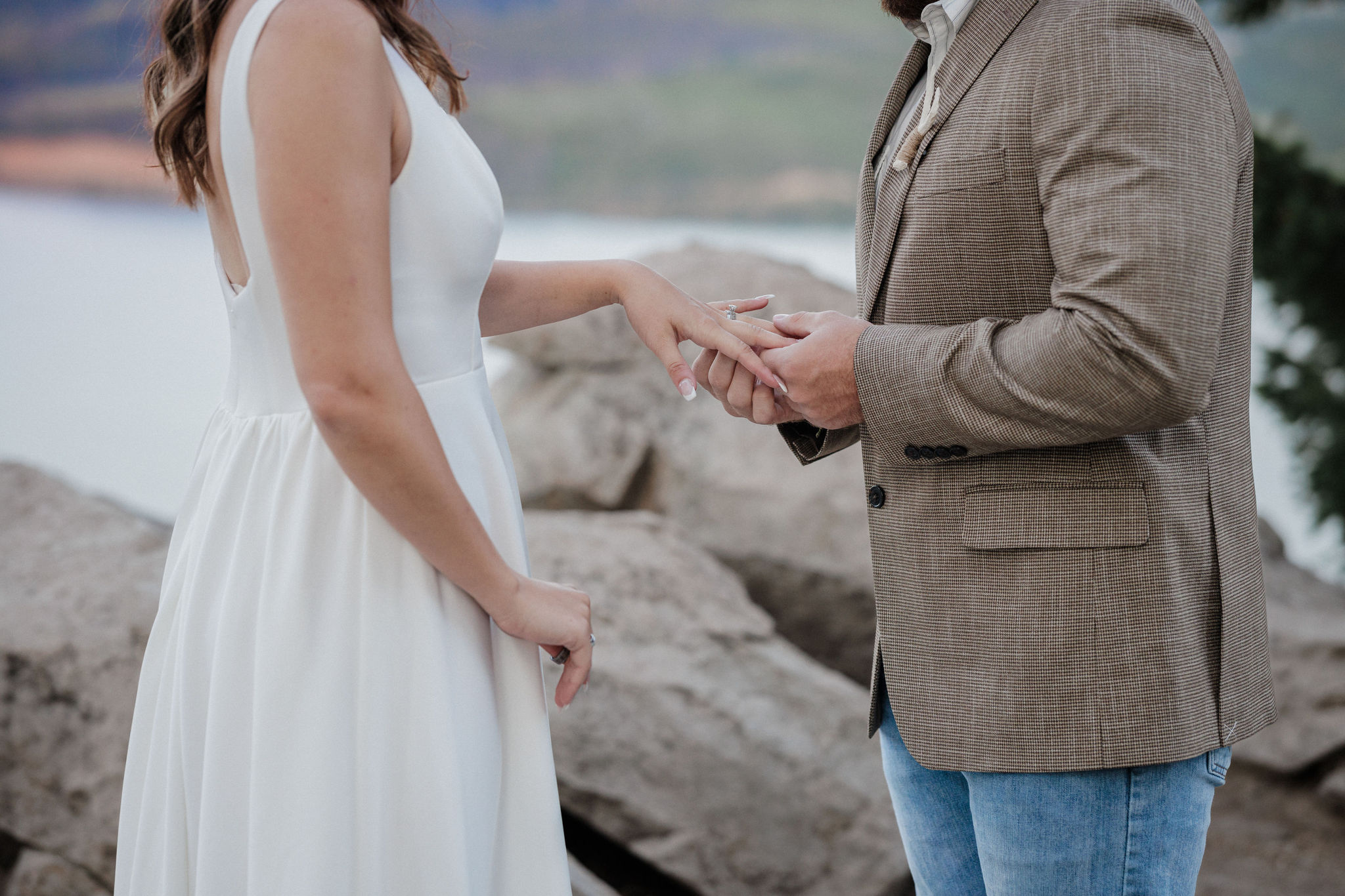 groom puts wedding ring on brides finger