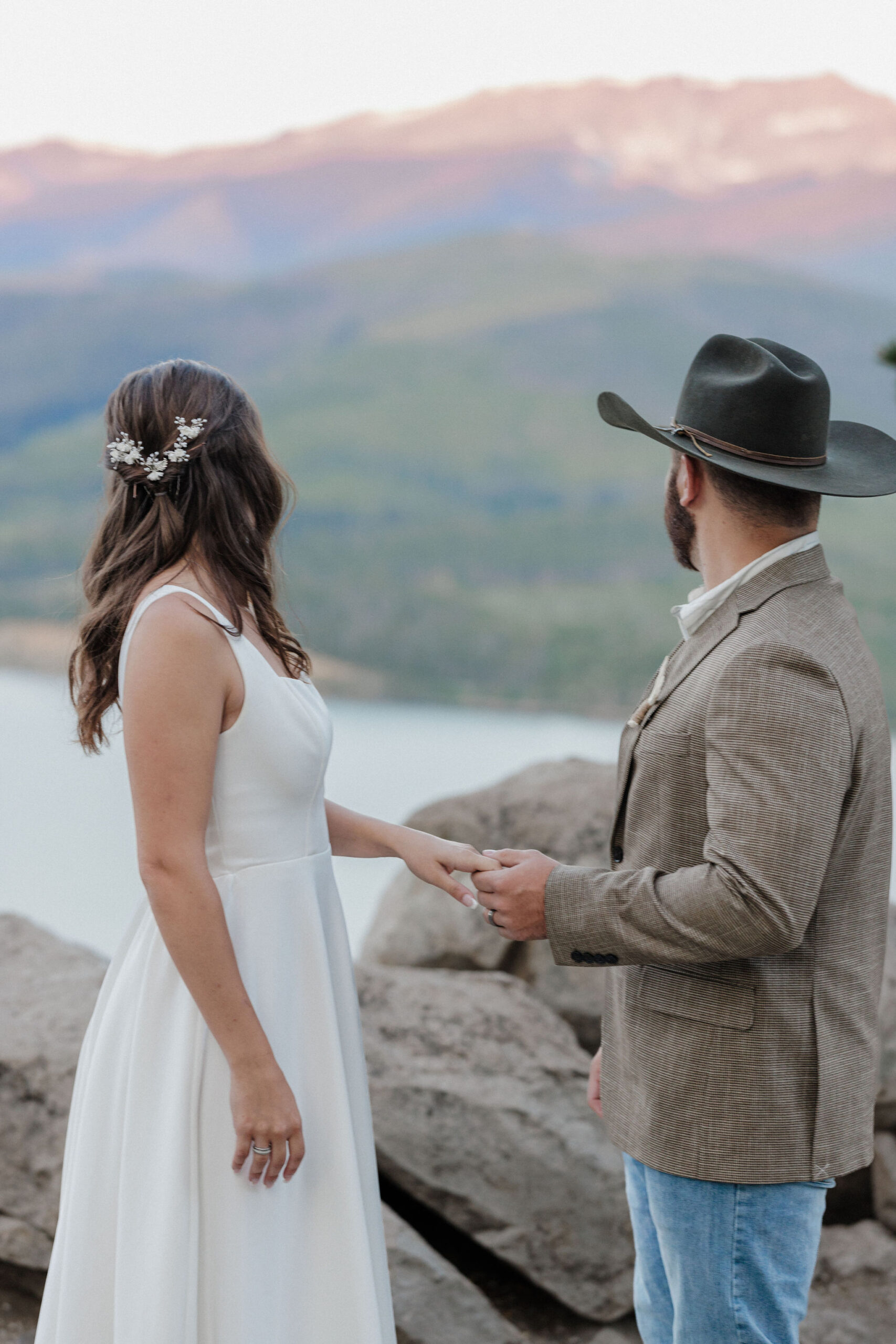 bride and groom look out at sunrise over the mountains during elopement ceremony