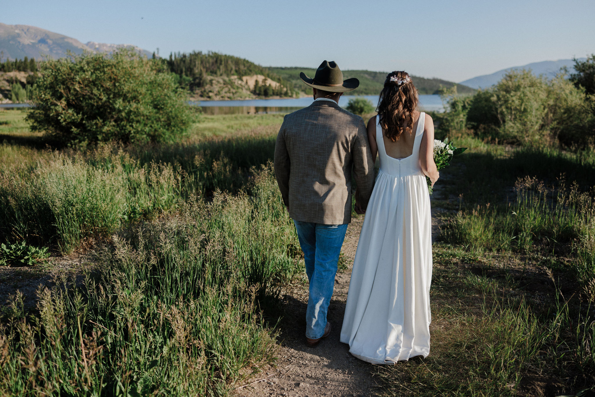 bride and groom walk towards lake dillon while taking elopement photos