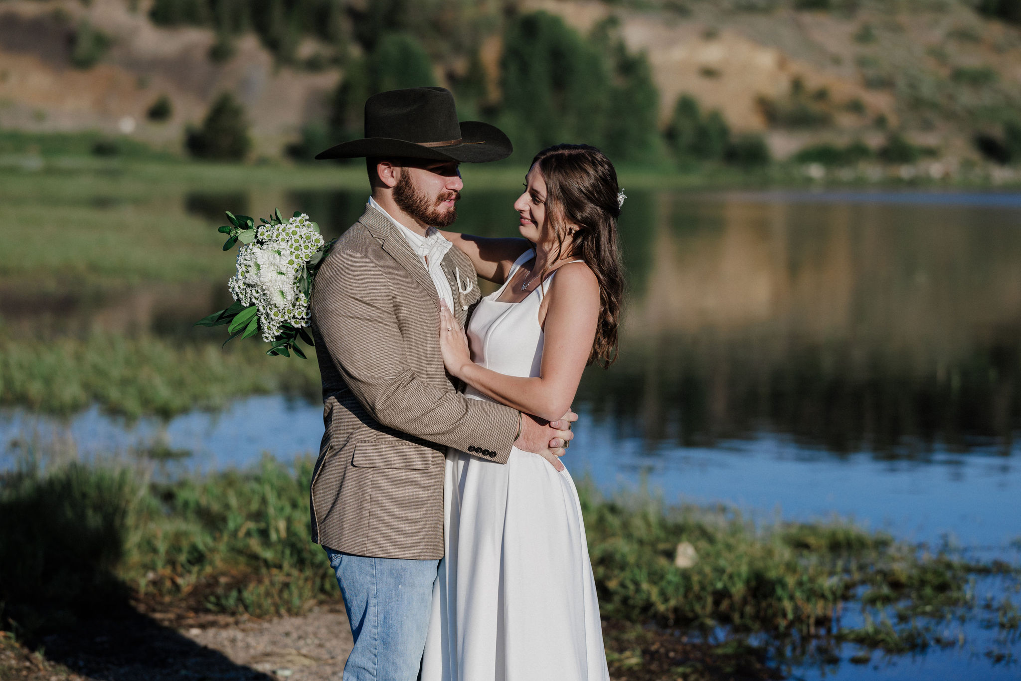 bride and groom smile at each other as they take wedding photos