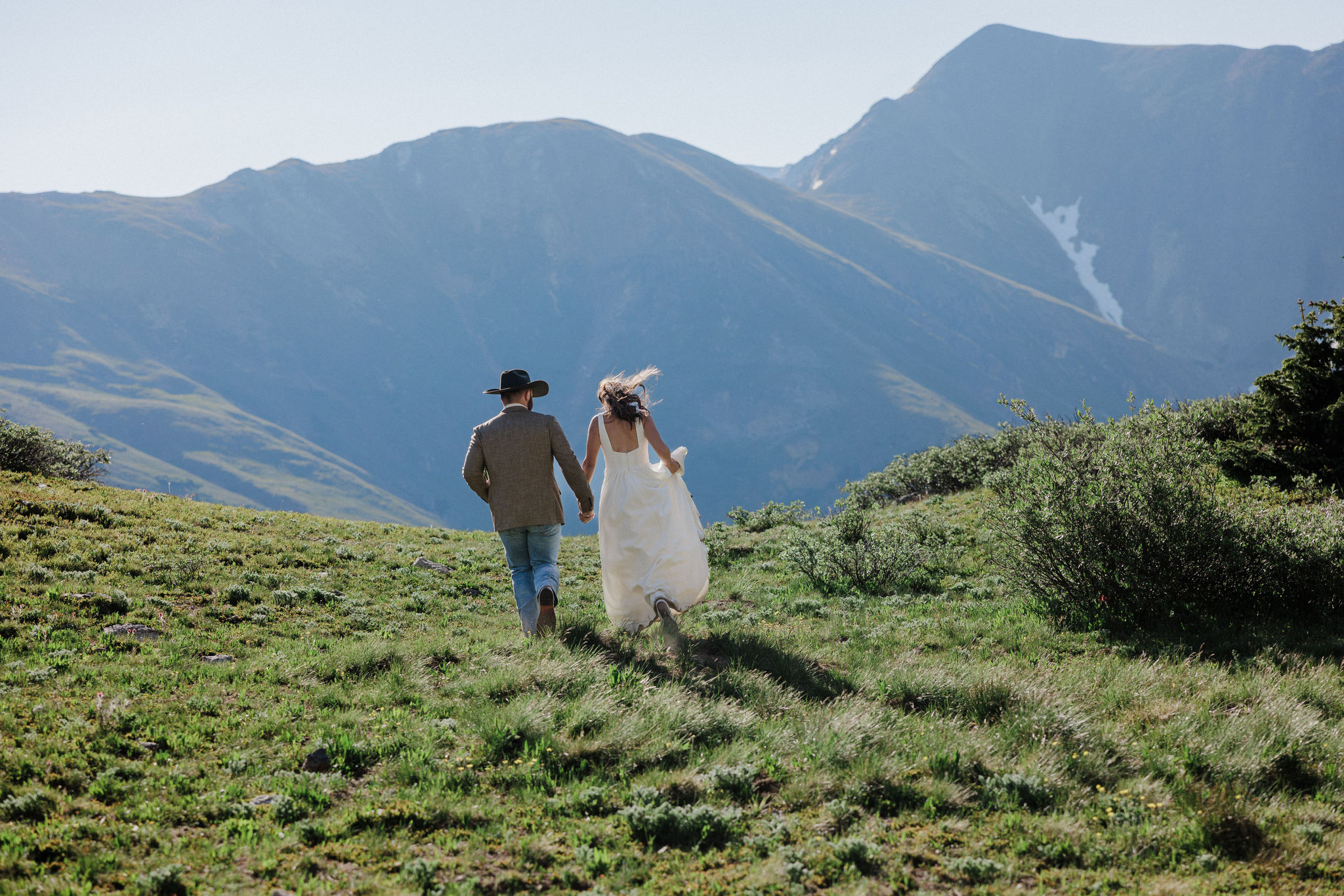 bride and groom run hand in hand at Pass Lake during sunrise elopement photos