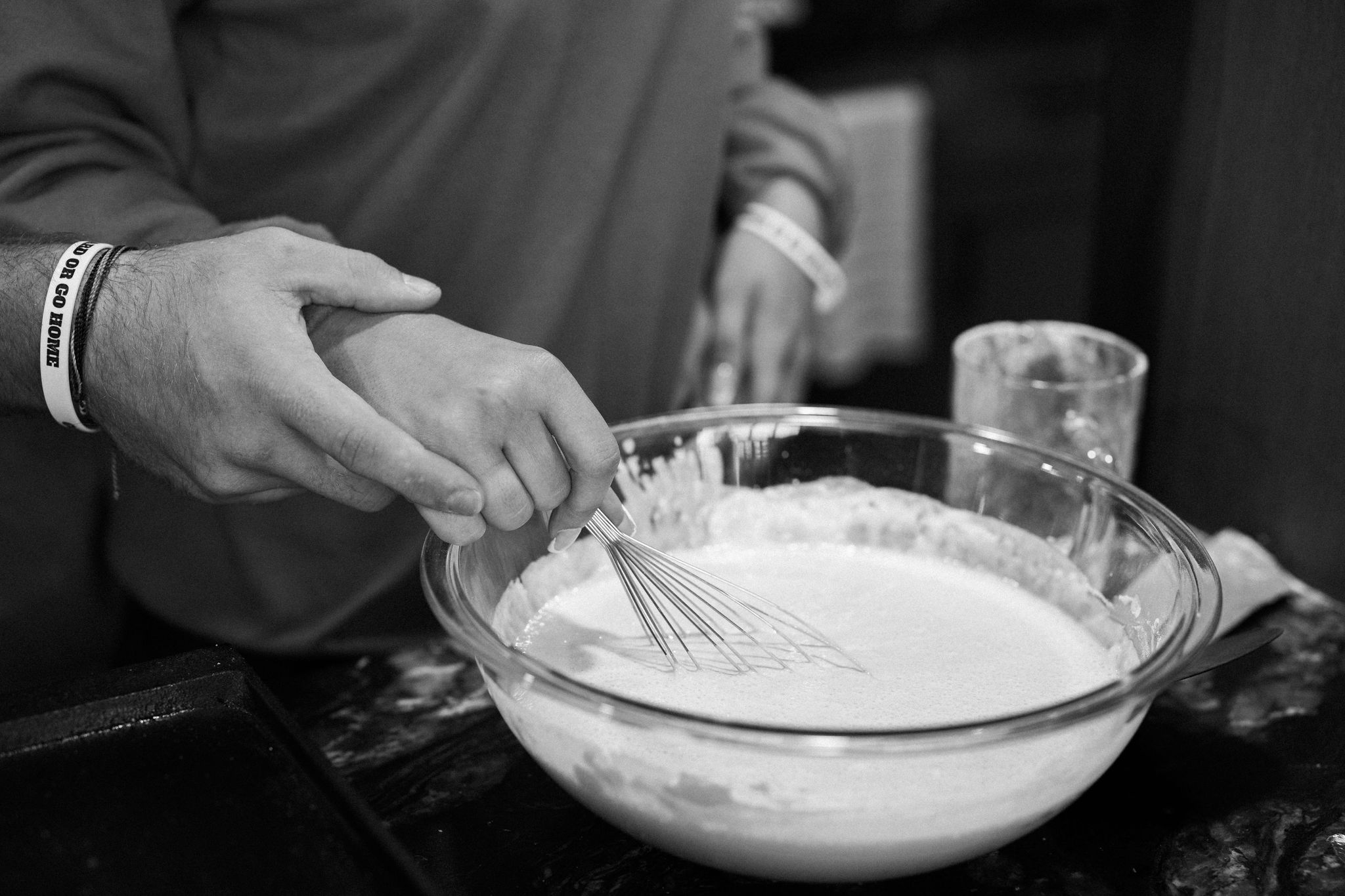 bride and groom stir pancake mix for an after-elopement breakfast