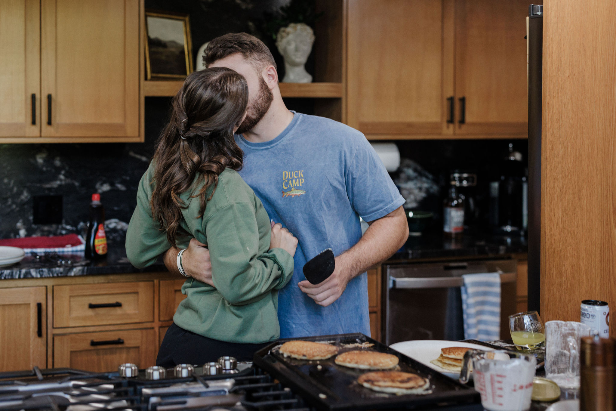 bride and groom kiss while they make breakfast after their sunrise elopement ceremony