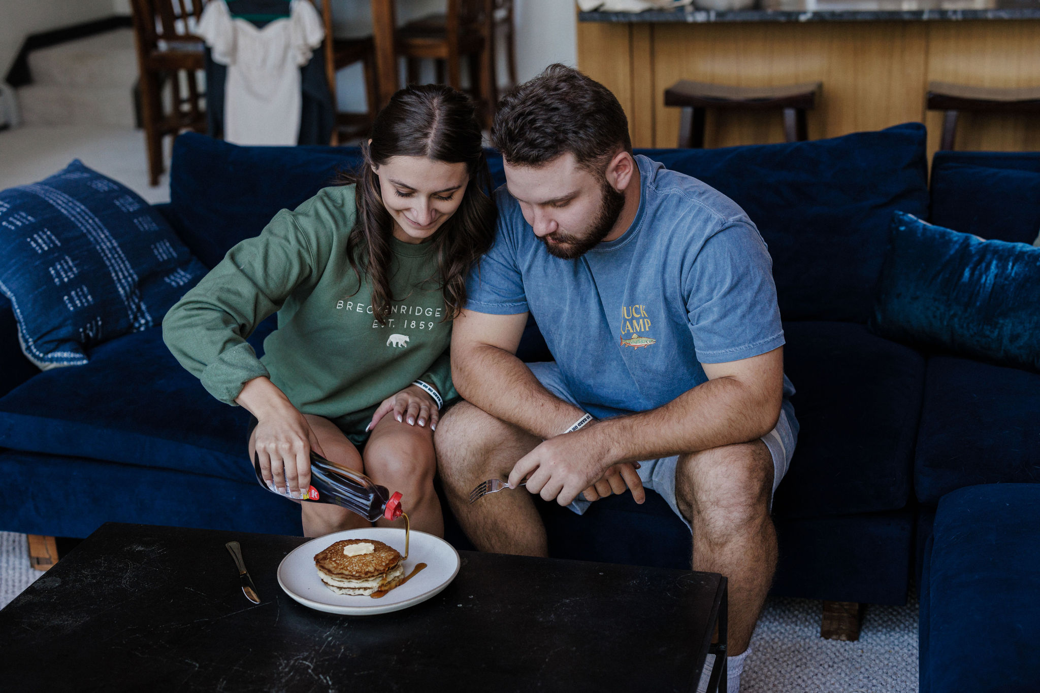 bride and groom pour syrup on pancakes during after-elopement breakfast