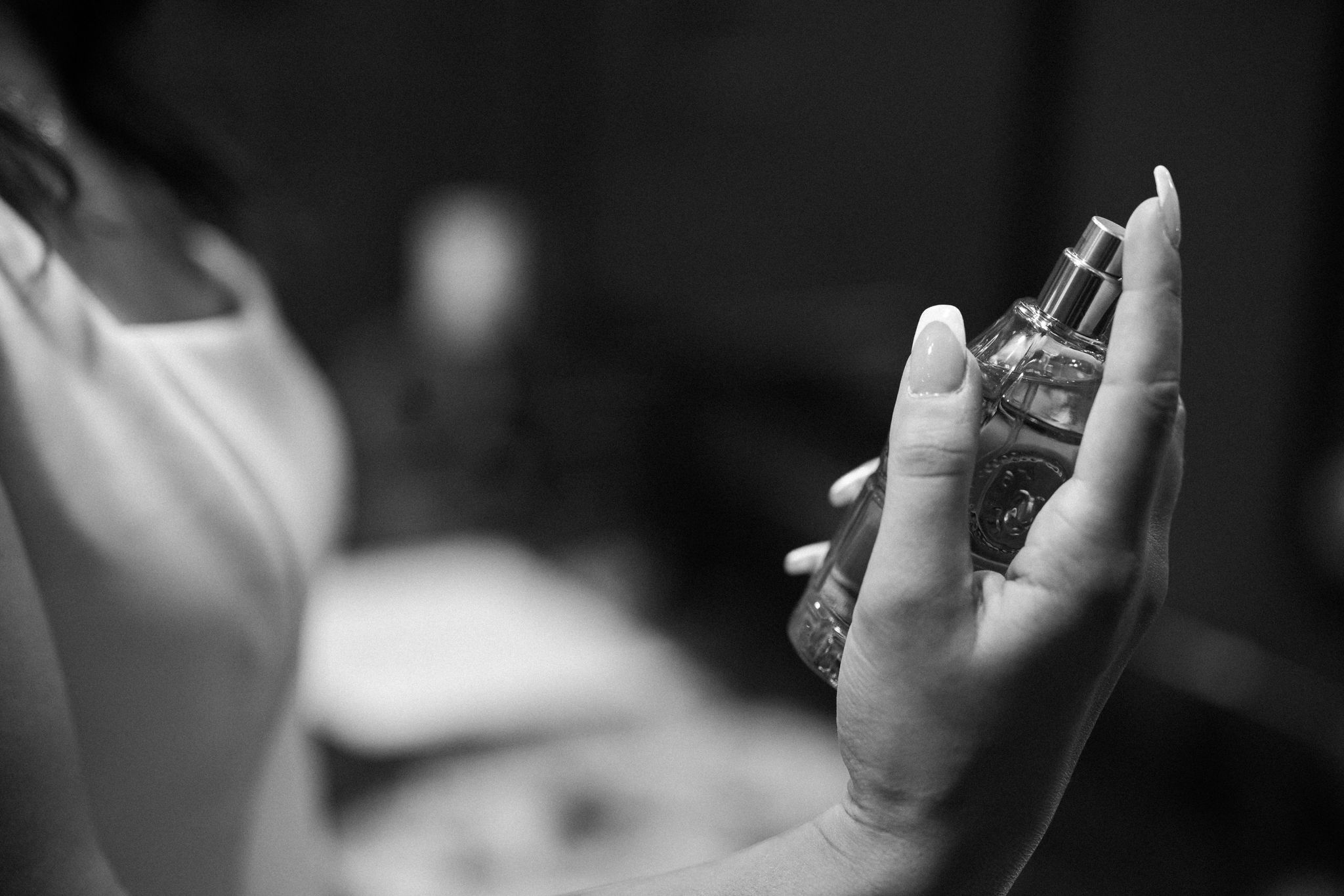 bride holds perfume while getting ready