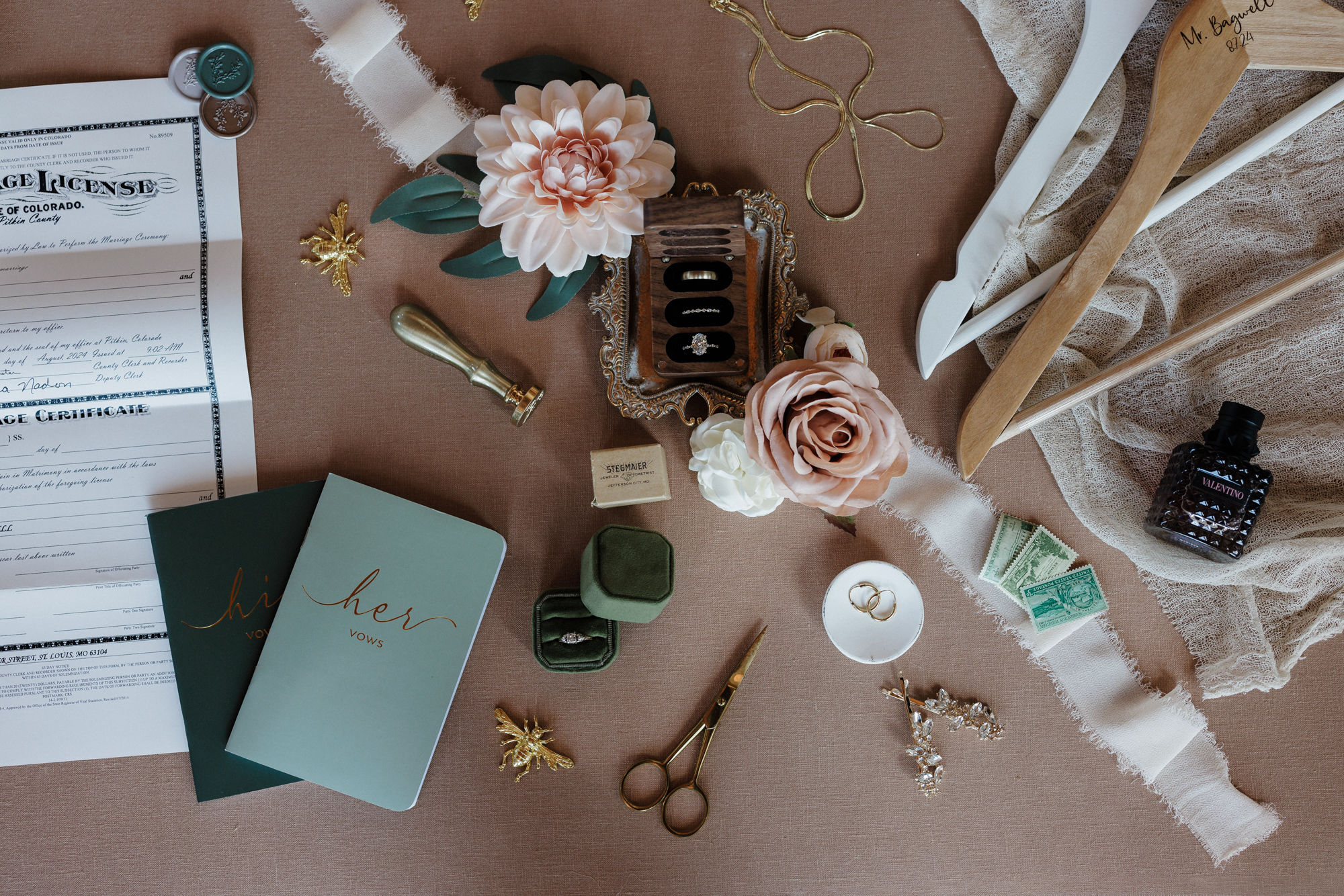 close up image of wedding details: marriage license, wedding vow books, florals, jewlery, wedding rings, ring box