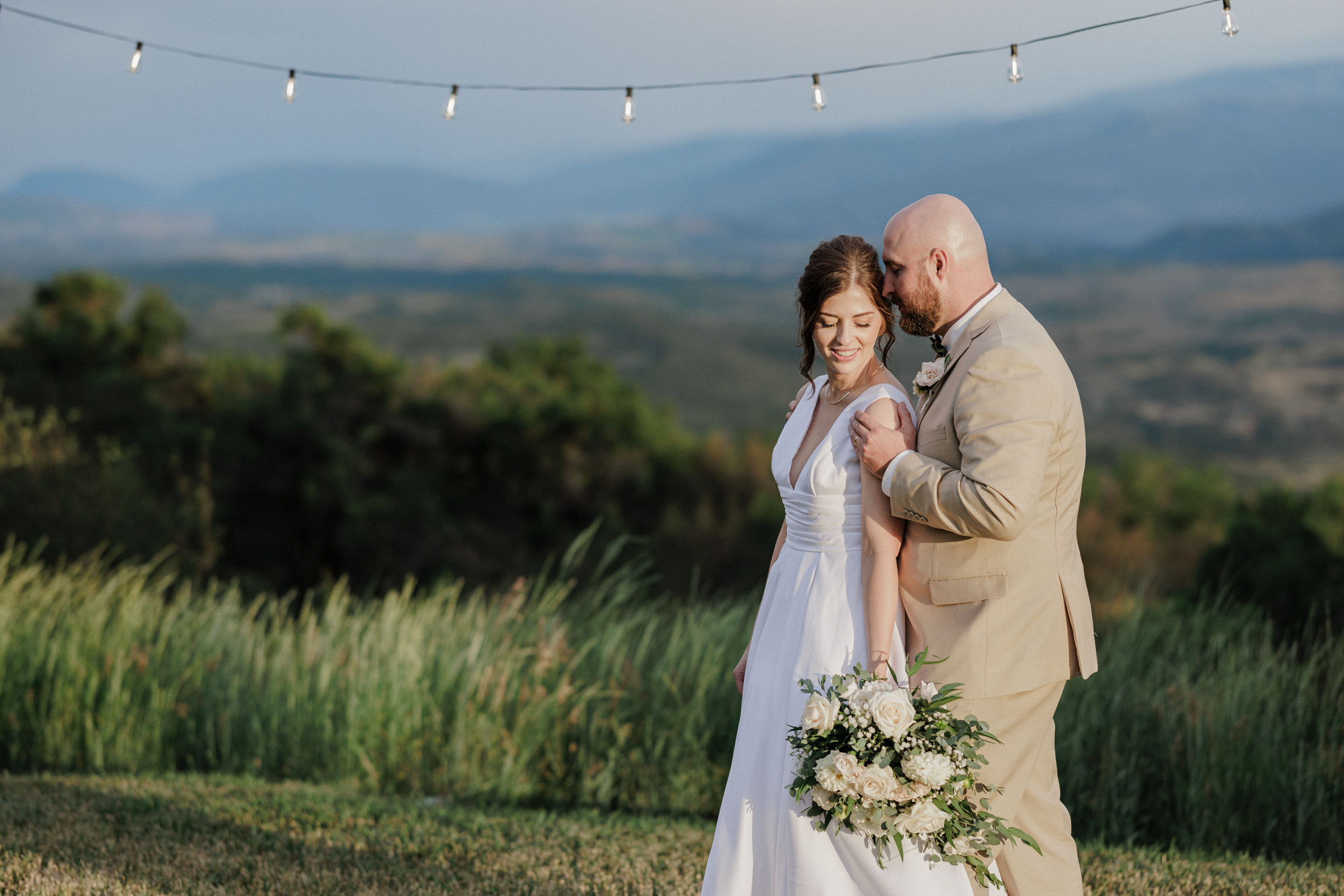 bride and groom pose for colorado wedding photographer during reception