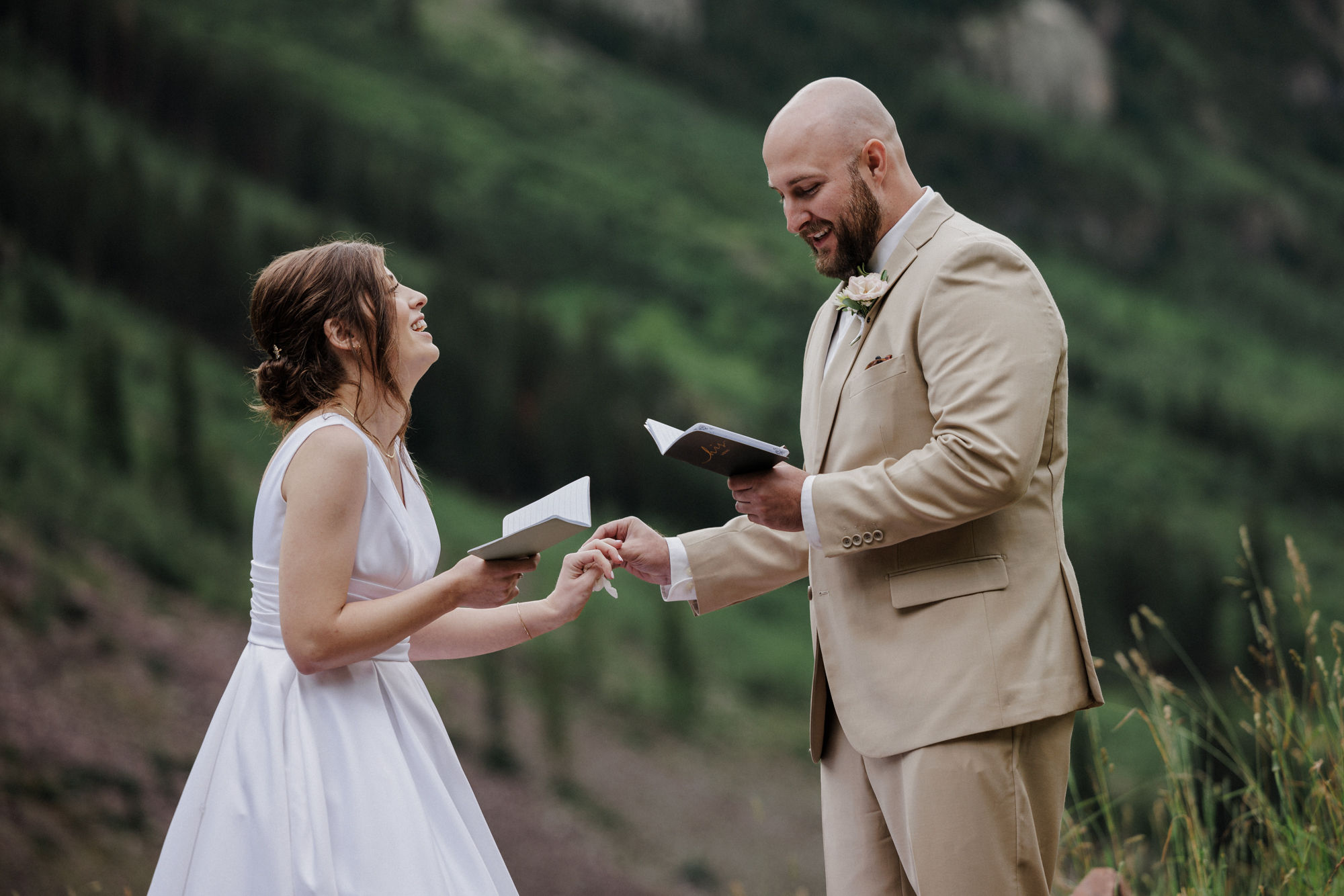 bride and groom laugh as they say their wedding vows in aspen colorado