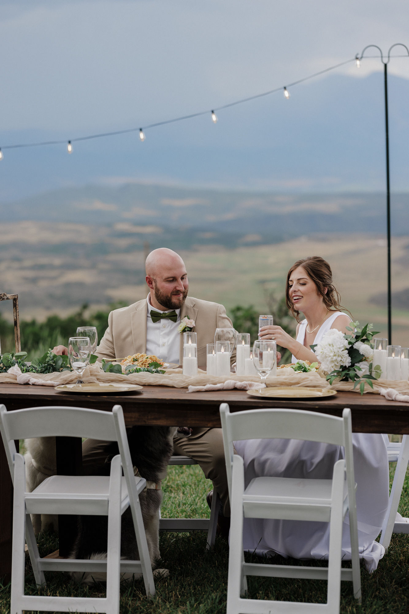 bride and groom sit at dinner table to eat