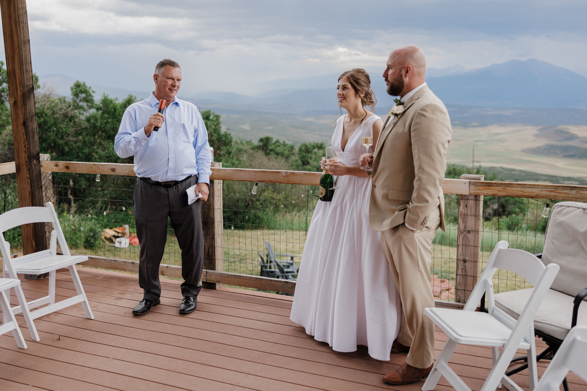 bride and groom smile as father says wedding toasts