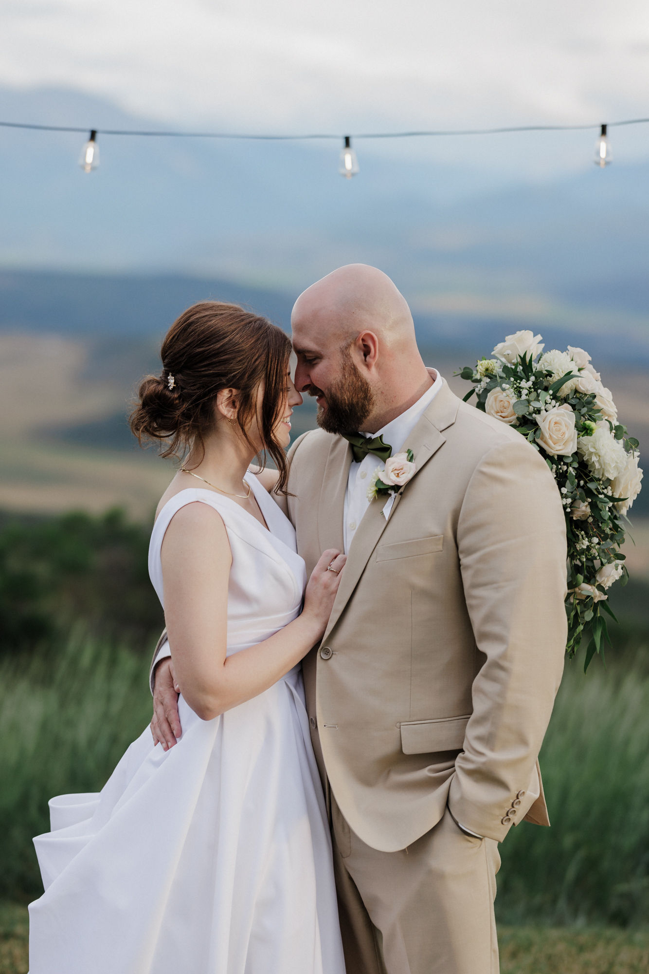 bride and groom put their heads together while taking wedding pictures