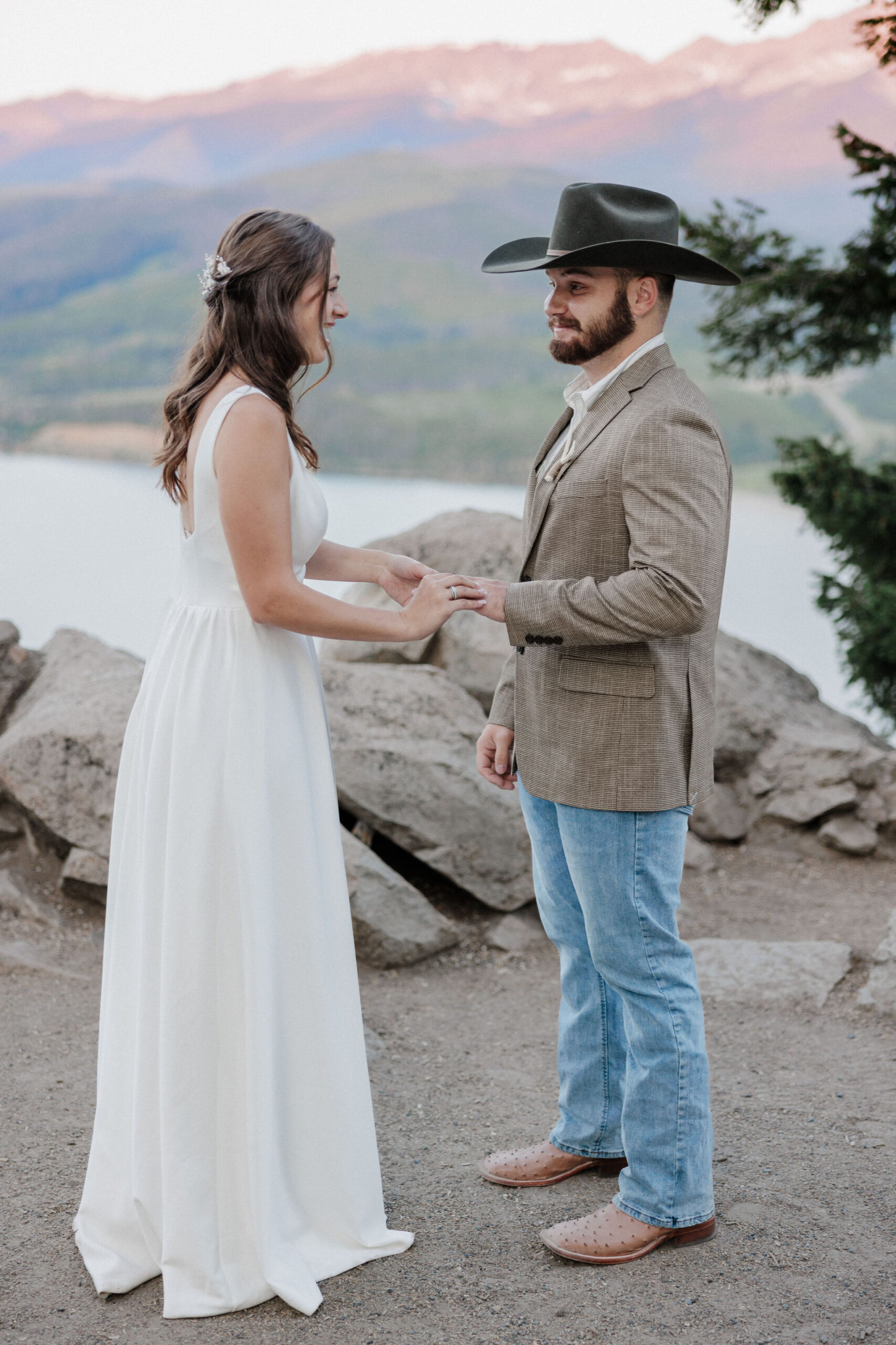 bride puts ring on grooms finger at sapphire point overlook in breckenridge colorado