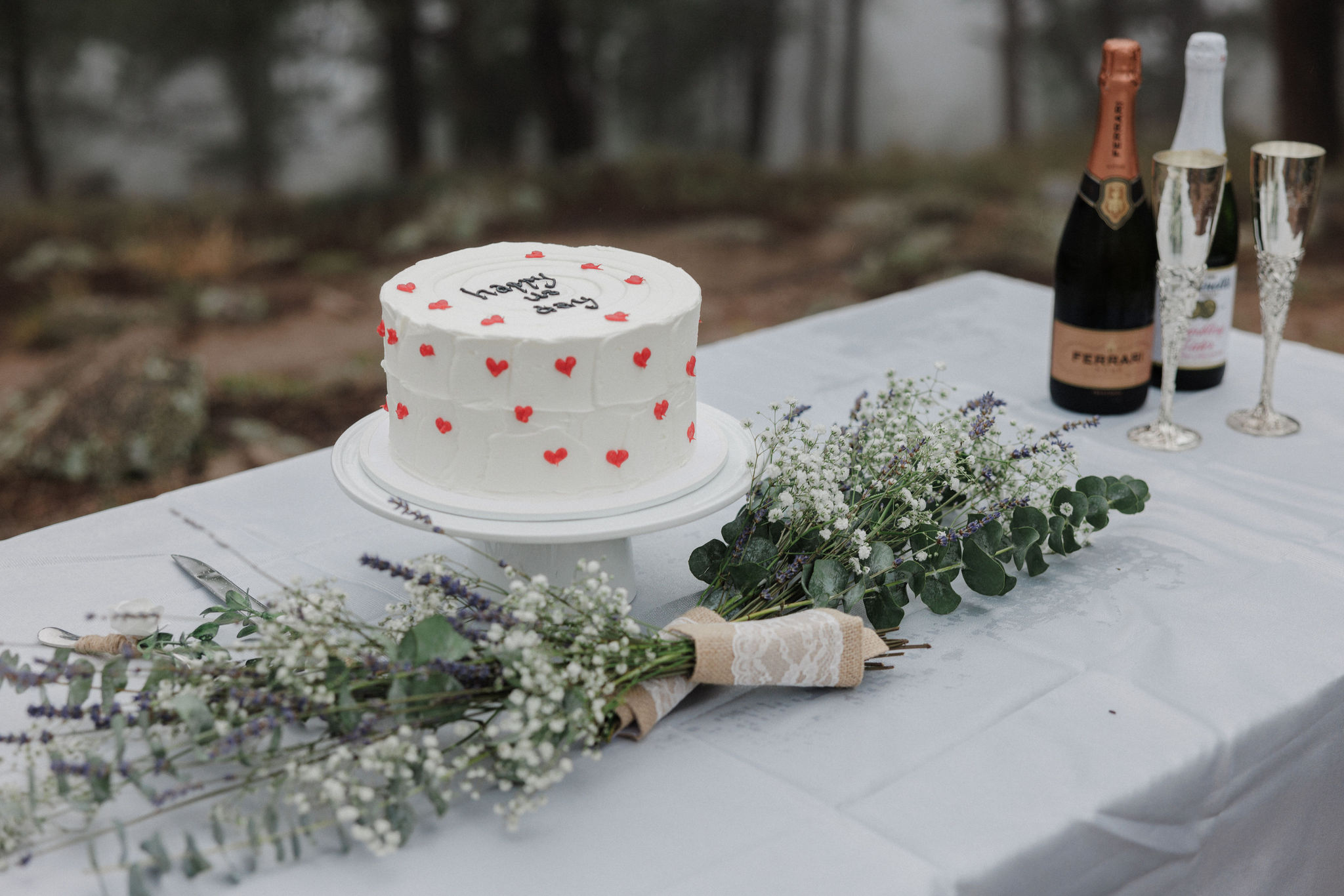 elopement cake sits on table with greenery decor in the mountains