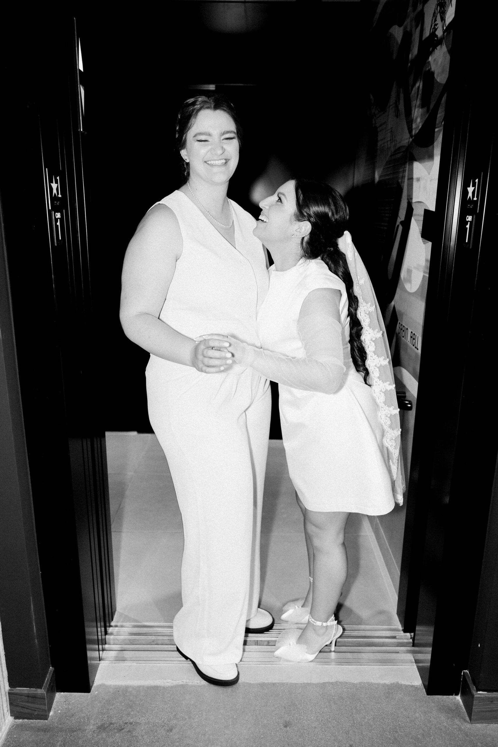 two brides pose for elopement photos in boulder colorado hotel elevator