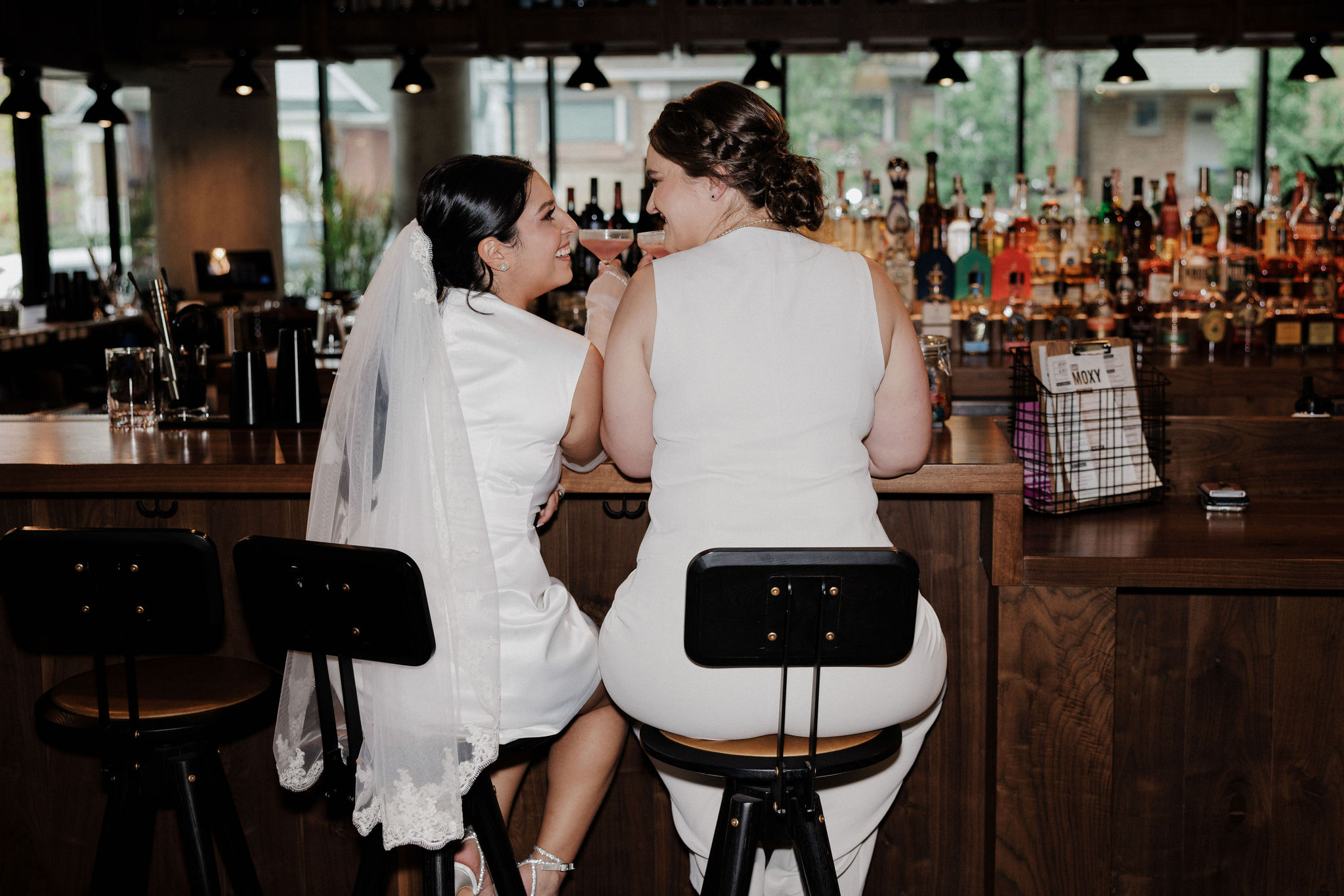 lgbtq+ couple sits at hotel bar during boulder colorado elopement