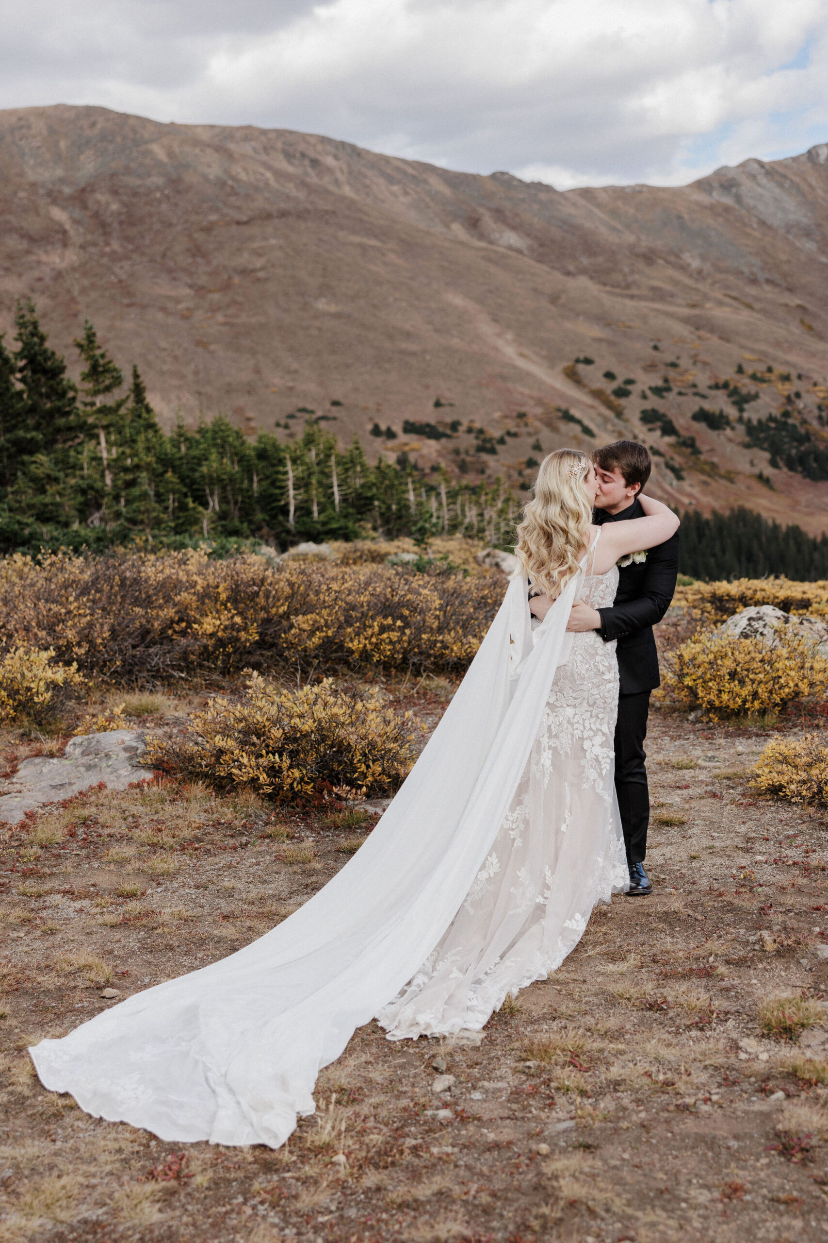 bride and groom kiss during colorado mountain wedding photos