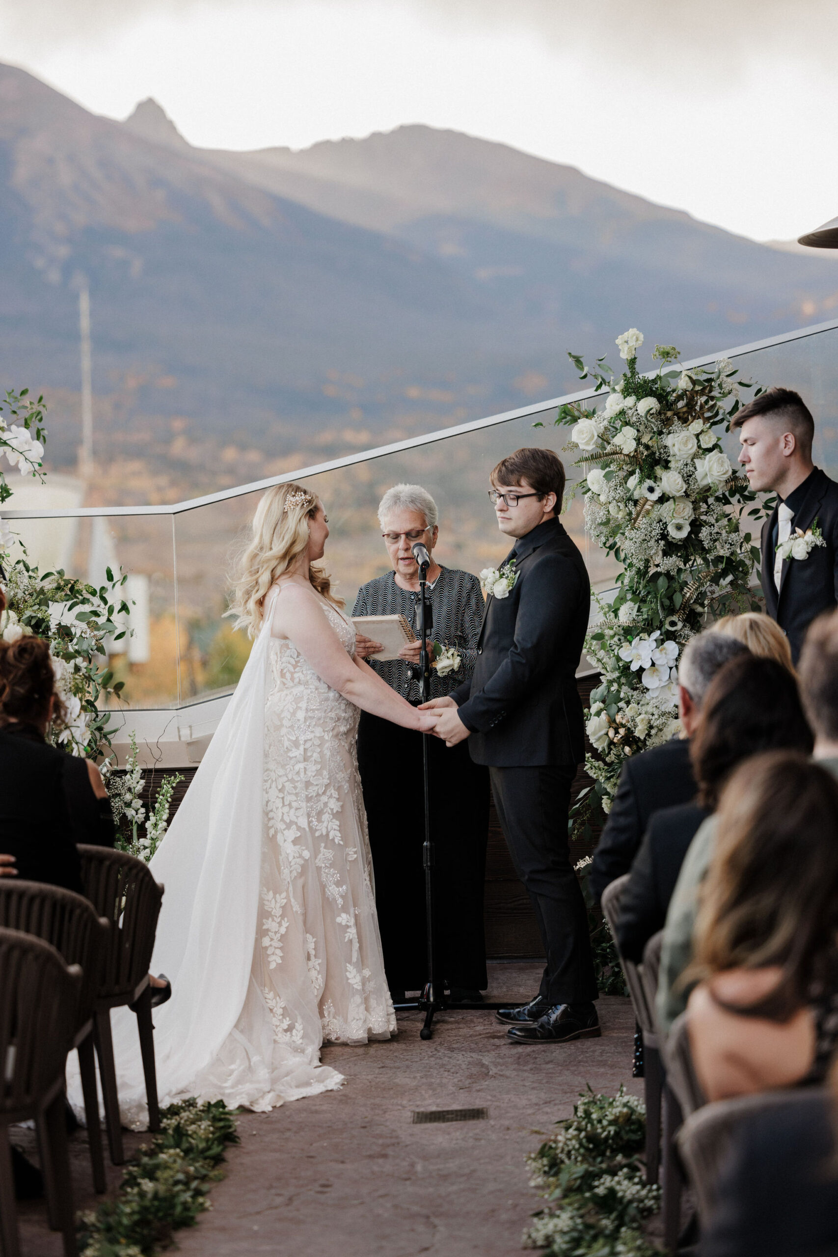 bride and groom stand during micro wedding ceremony and hold hands