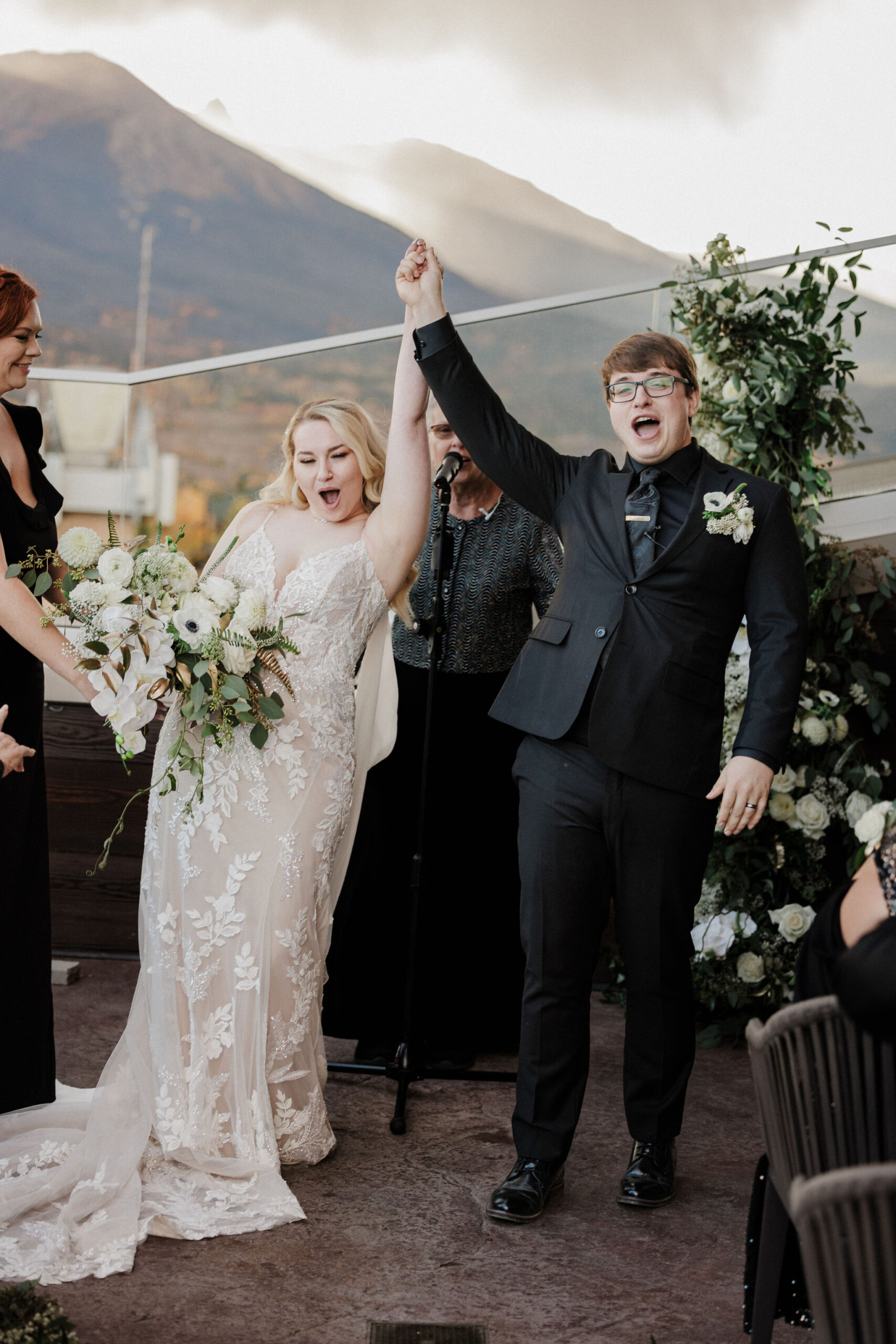 bride and groom smile with hands in the air during micro wedding ceremony