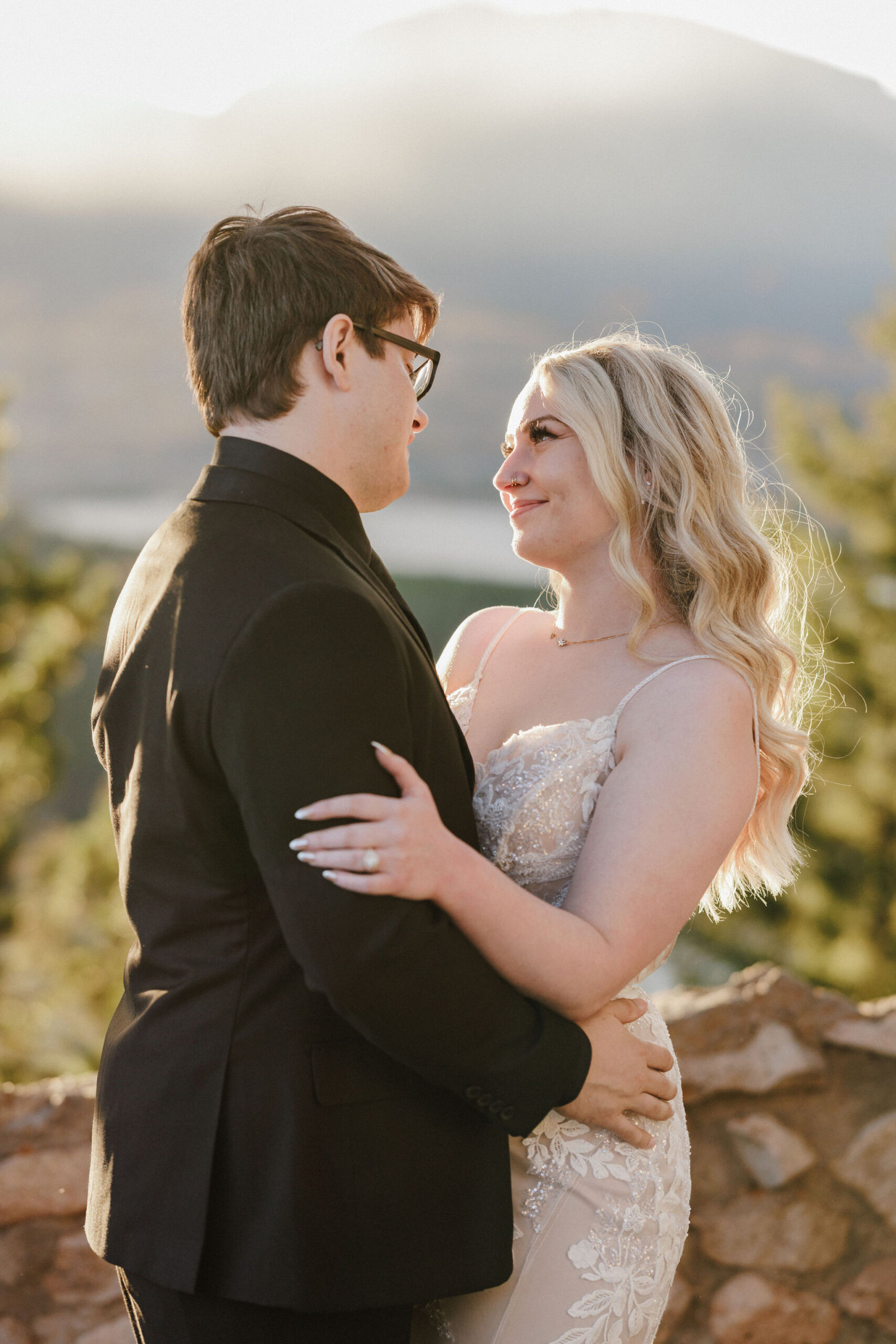 bride and groom smile at each other during wedding weekend photos