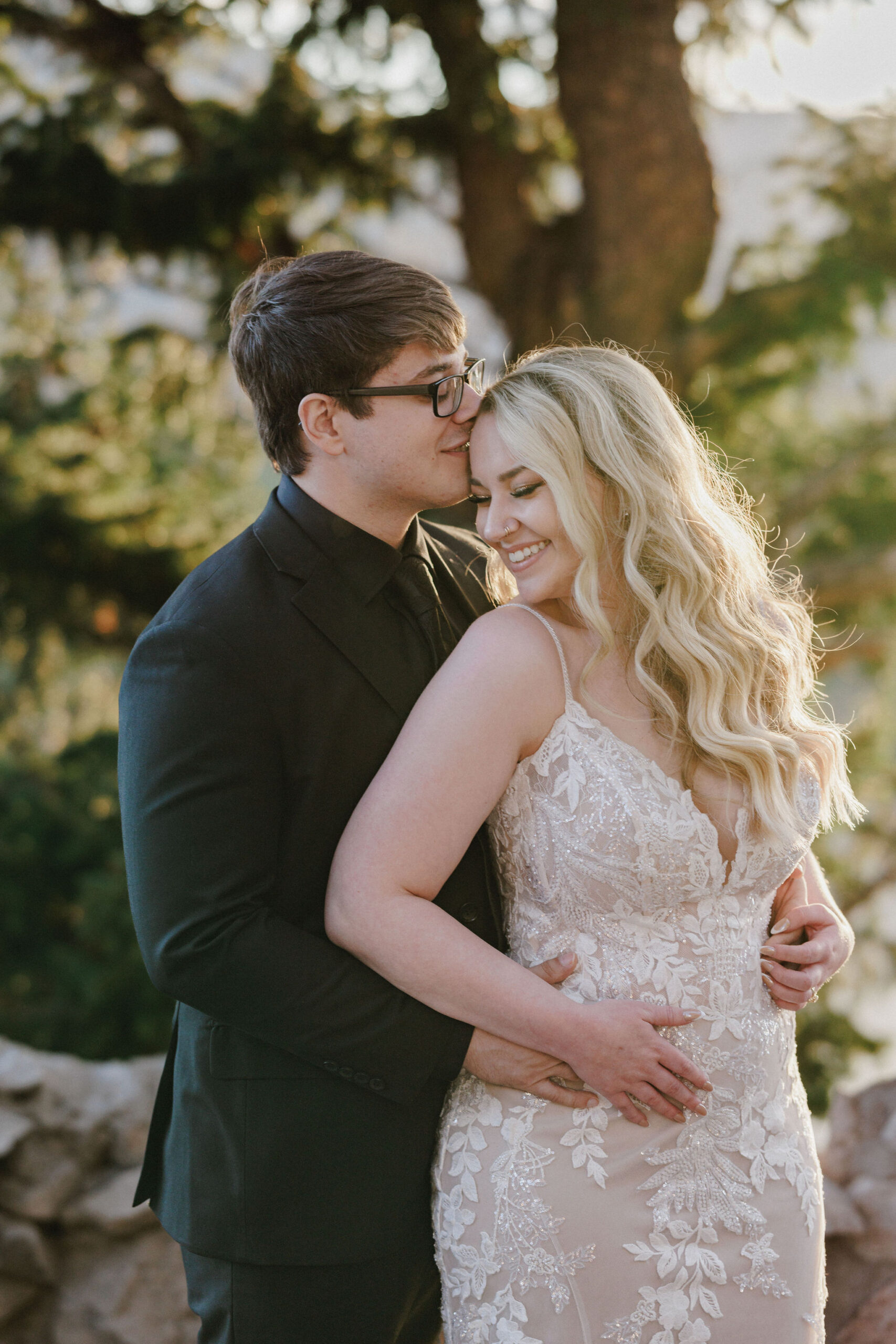 groom kisses brides head during colorado wedding photos