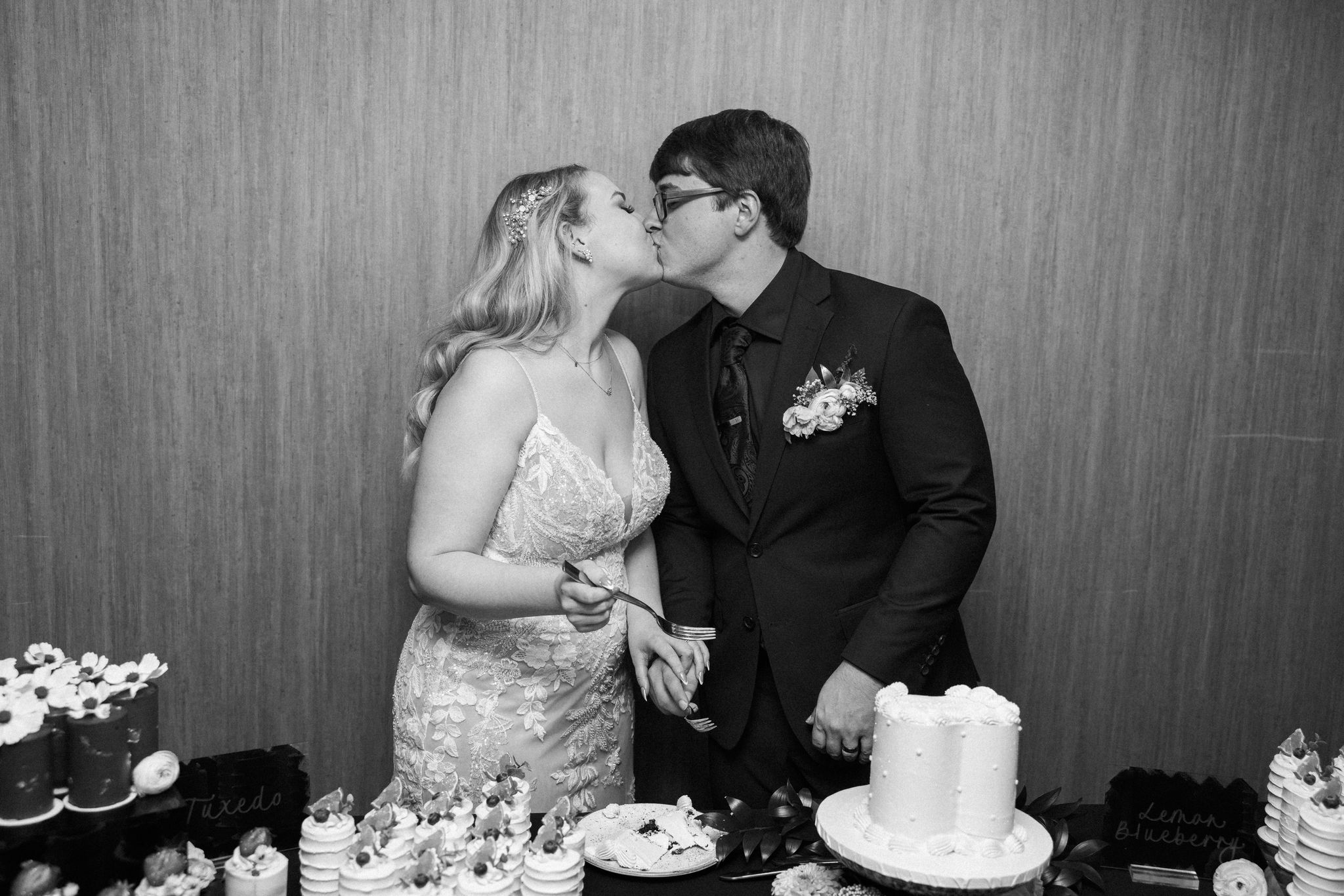 bride and groom kiss after cutting their wedding cake