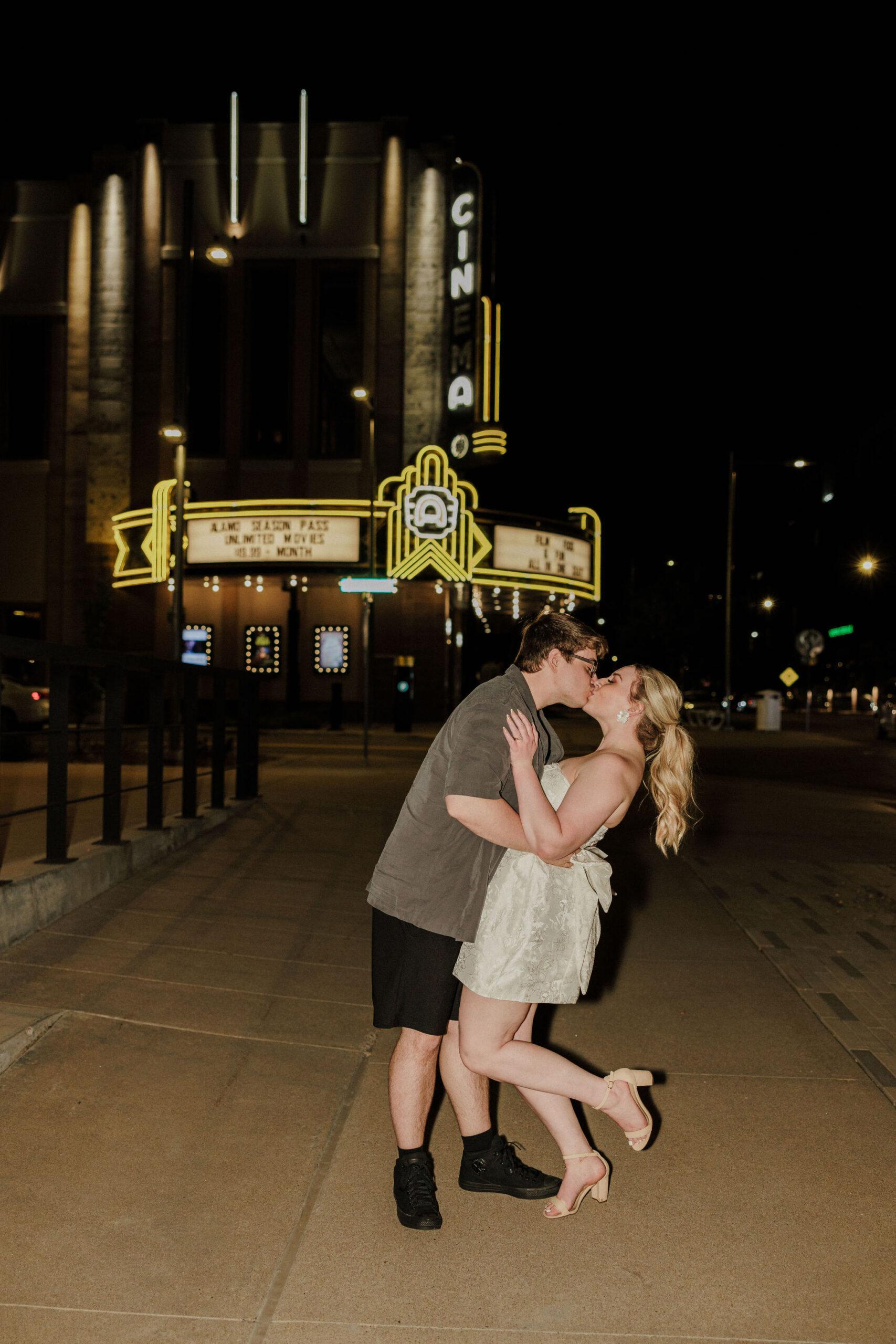 bride and groom kiss in front of downtown lights in denver