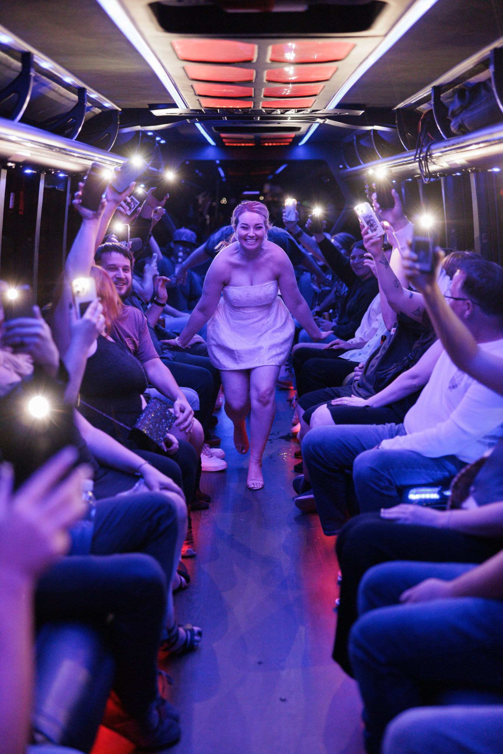 bride and groom run down aisle of party bus