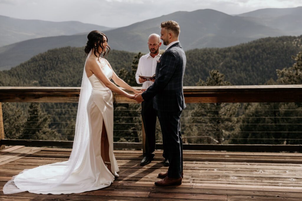 Bride and groom exchange vows during mountain Airbnb elopement.