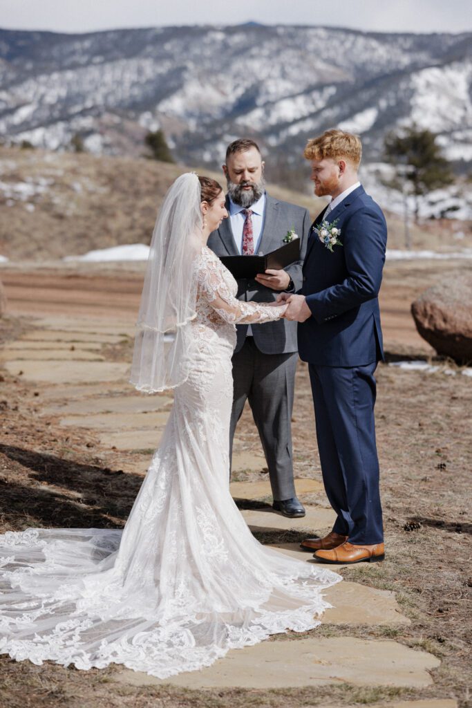 Bride and groom exchange vows during mountain Airbnb wedding day.