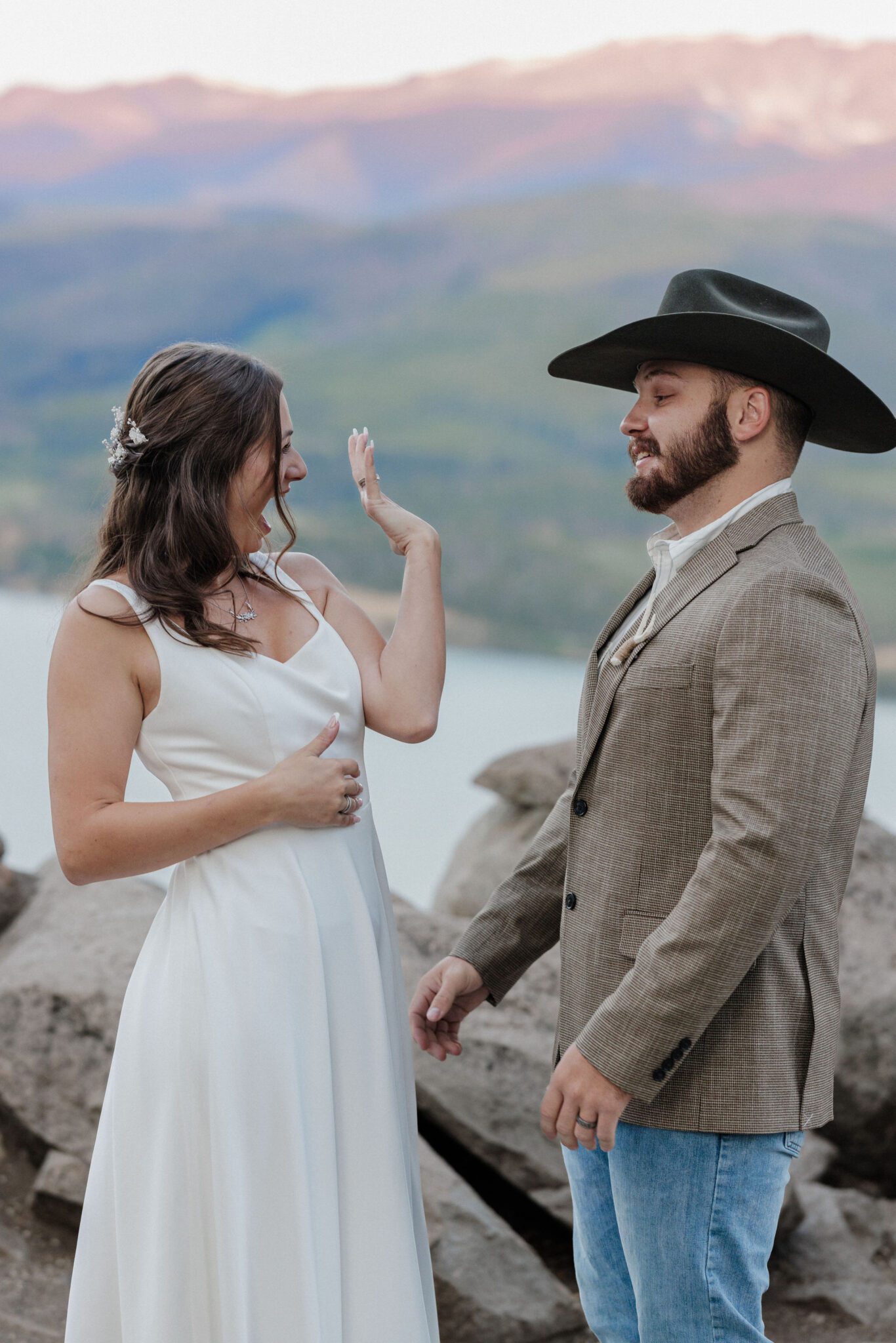 bridesmiles big as she shows the groom her new wedding ring during colorado elopement
