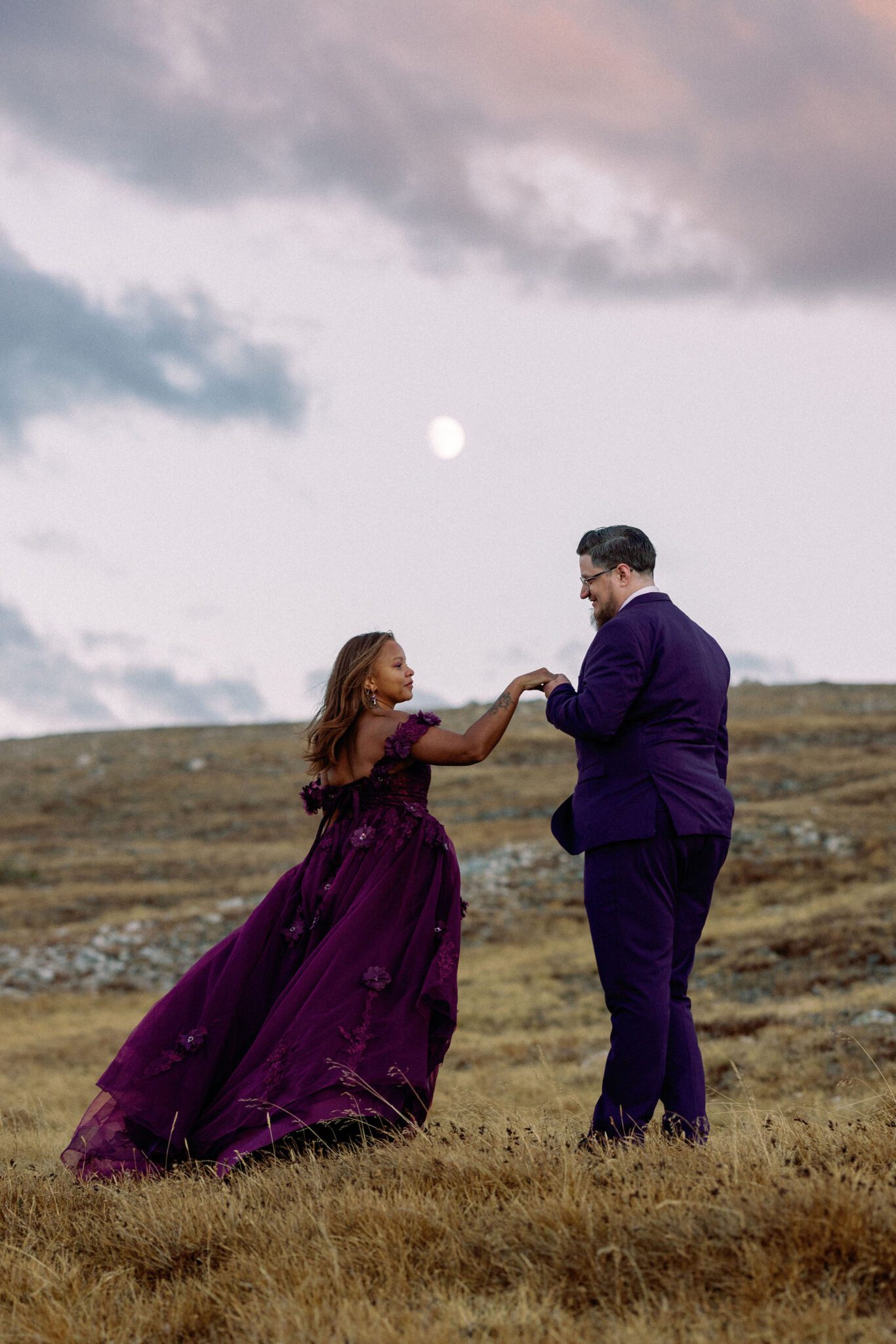 groom takes brides hand during sunset wedding photos in colorado