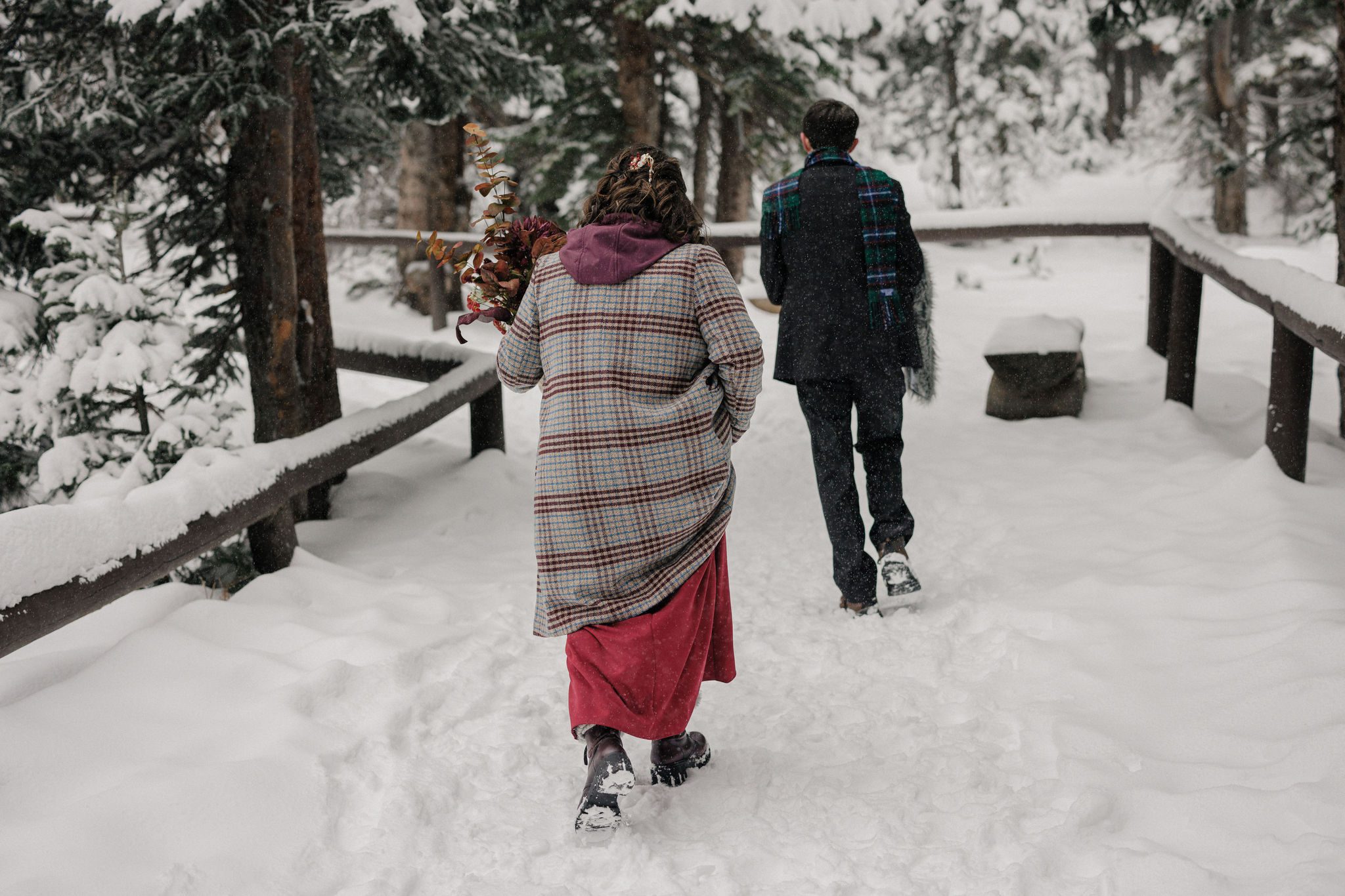 bride and groom hike to bear lake at rocky mountain national park for winter elopement ceremony