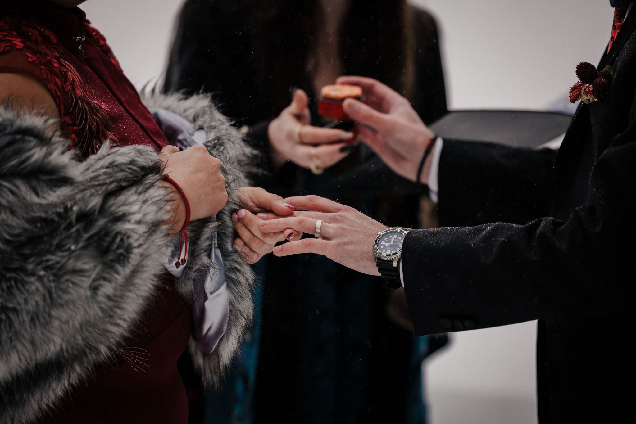 bride puts wedding ring on grooms finger