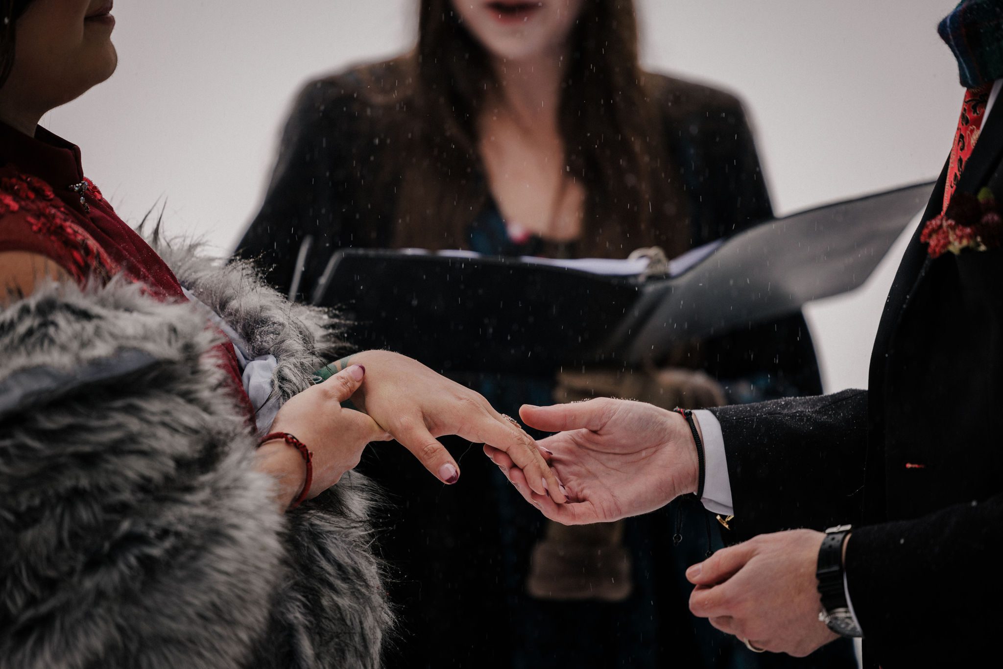 groom puts wedding ring on brides finger