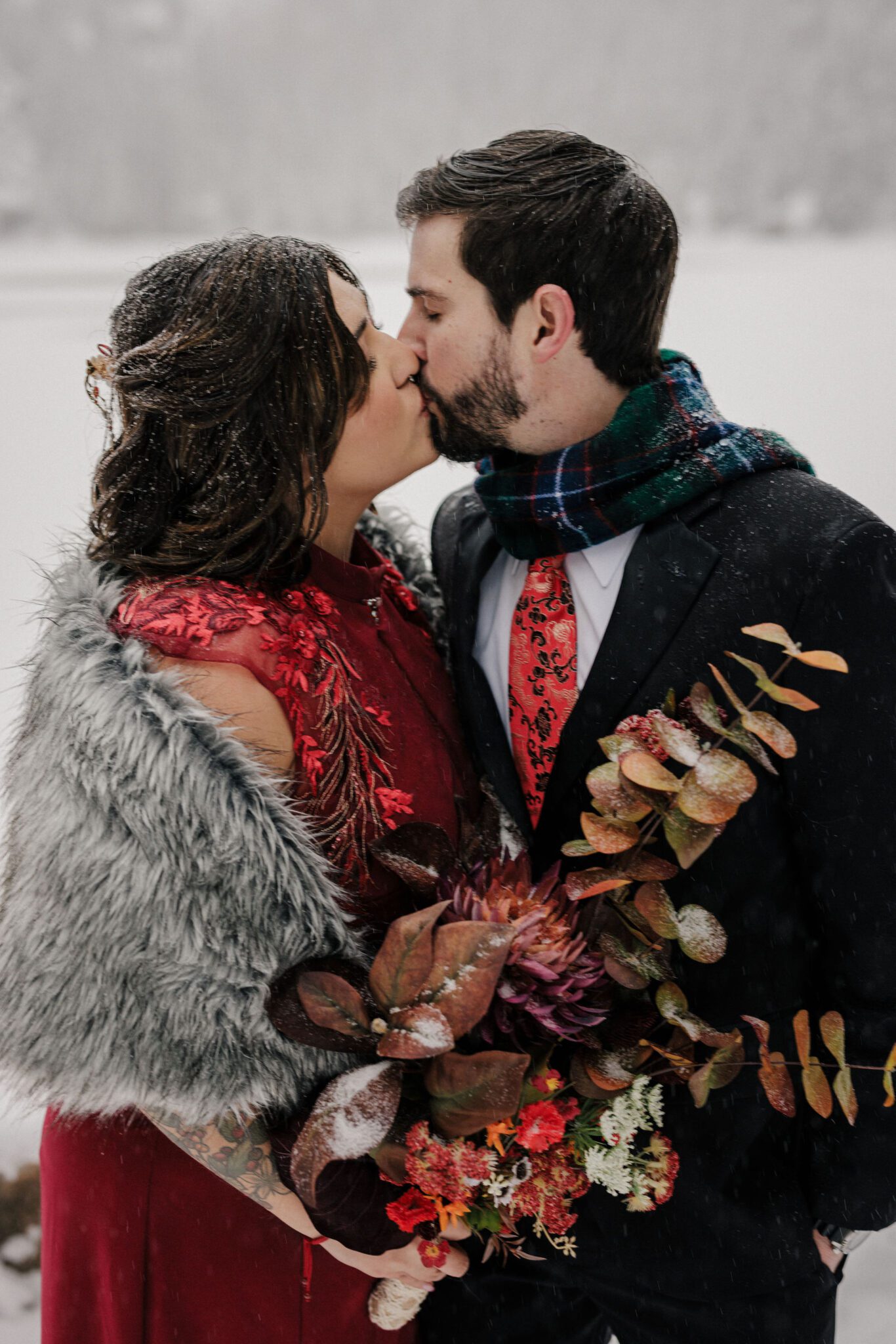 bride and groom kiss in front of bear lake at rocky mountain national park after elopement ceremony