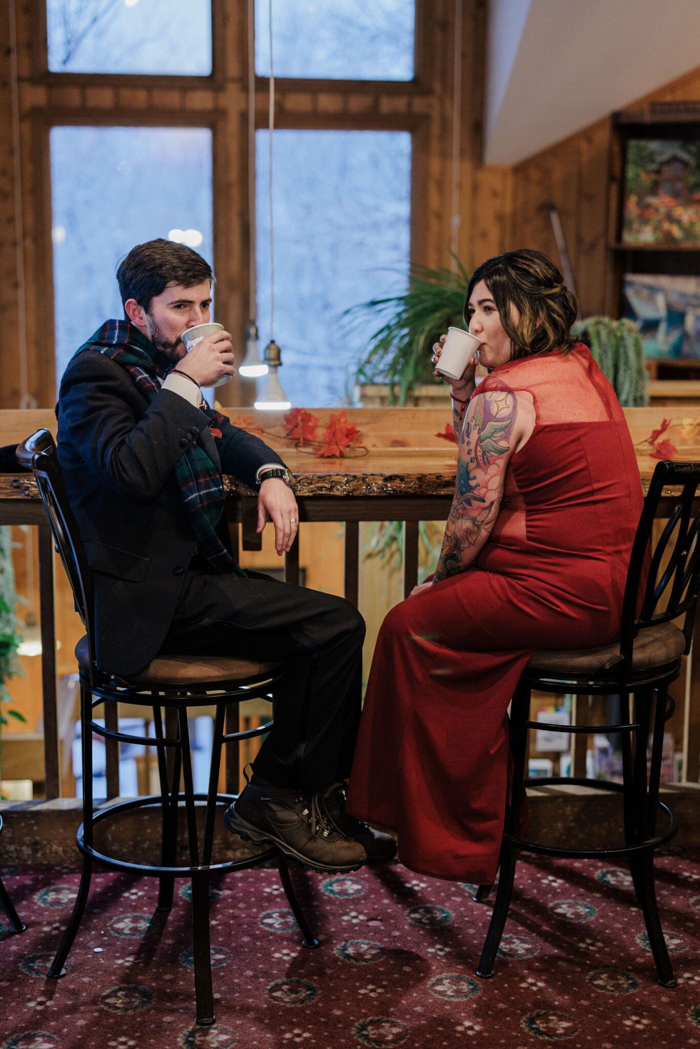bride and groom sit in cafe and drink coffee after colorado winter elopement