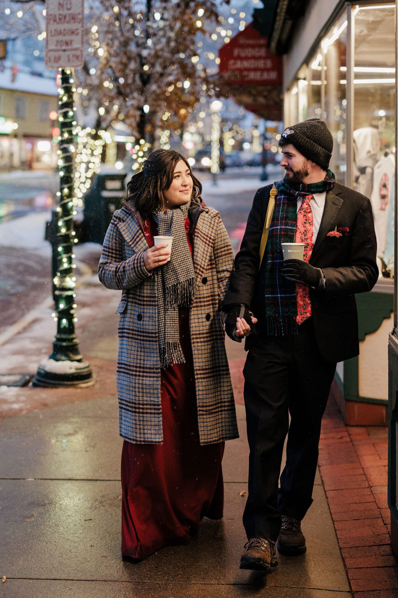 bride and groom hold hands and walk around estes park after winter elopement