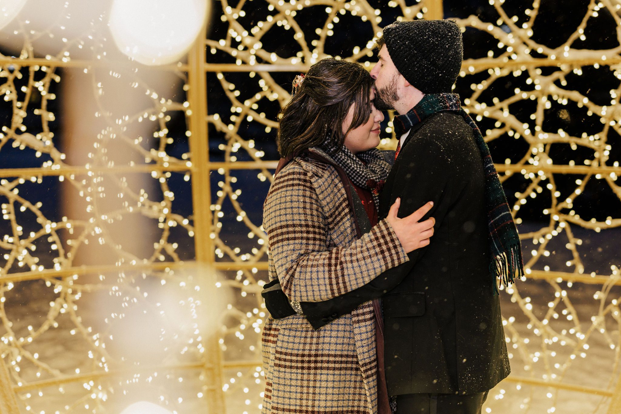 bride and groom pose inside christmas light display in estes park after their colorado winter elopement