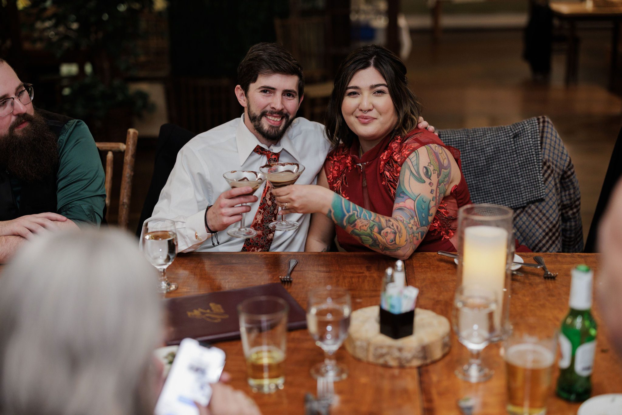 bride and groom cheers during post-elopement dinner