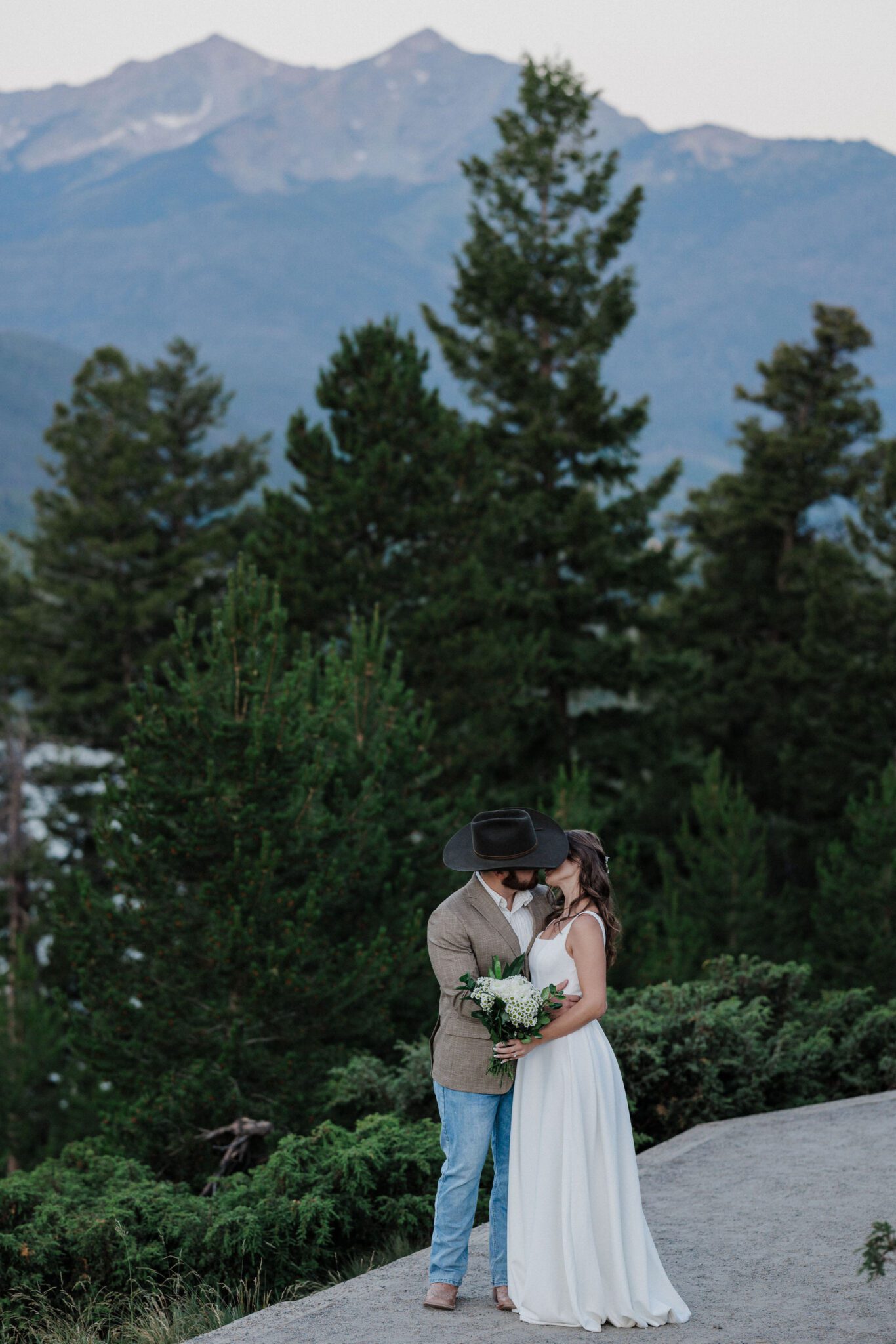 bride and groom kiss during colorado forest wedding