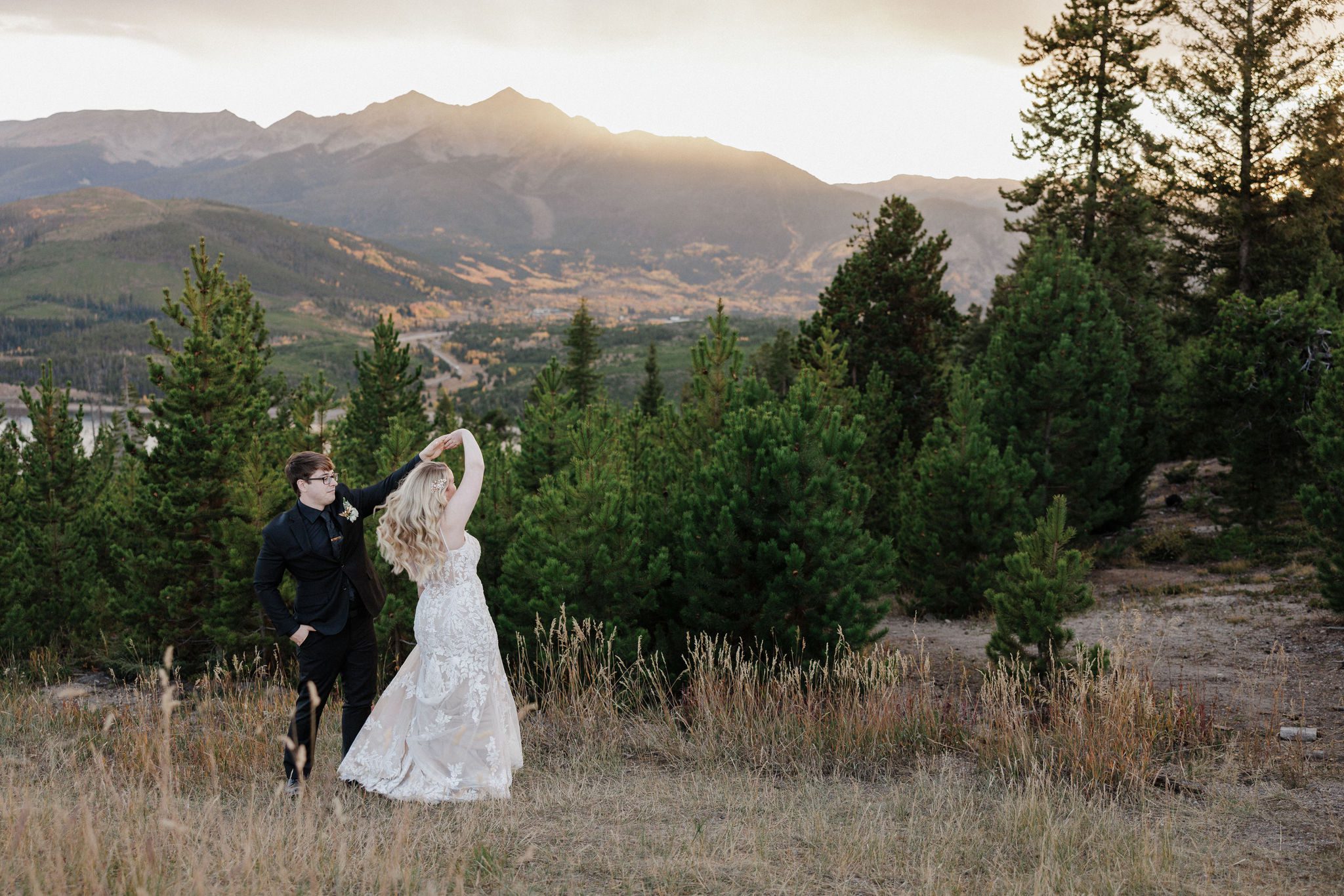 groom twirls bride in the colorado forest during fall micro wedding