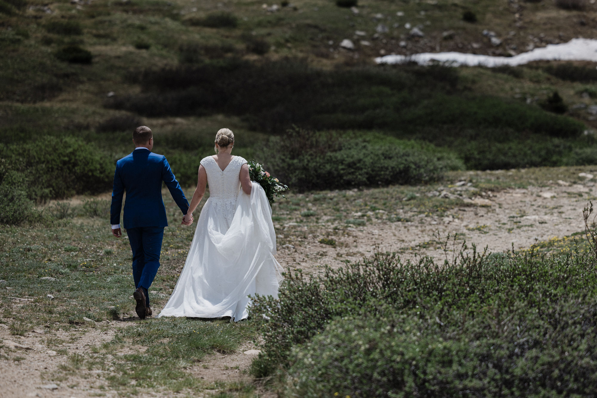 bride and groom hike down trail at colorado state park during intimate wedding