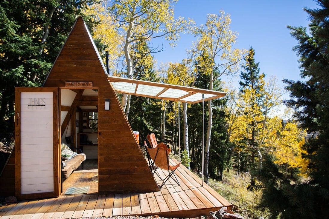 A-frame structure sits on a hill in the colorado forest, used for micro weddings and elopements