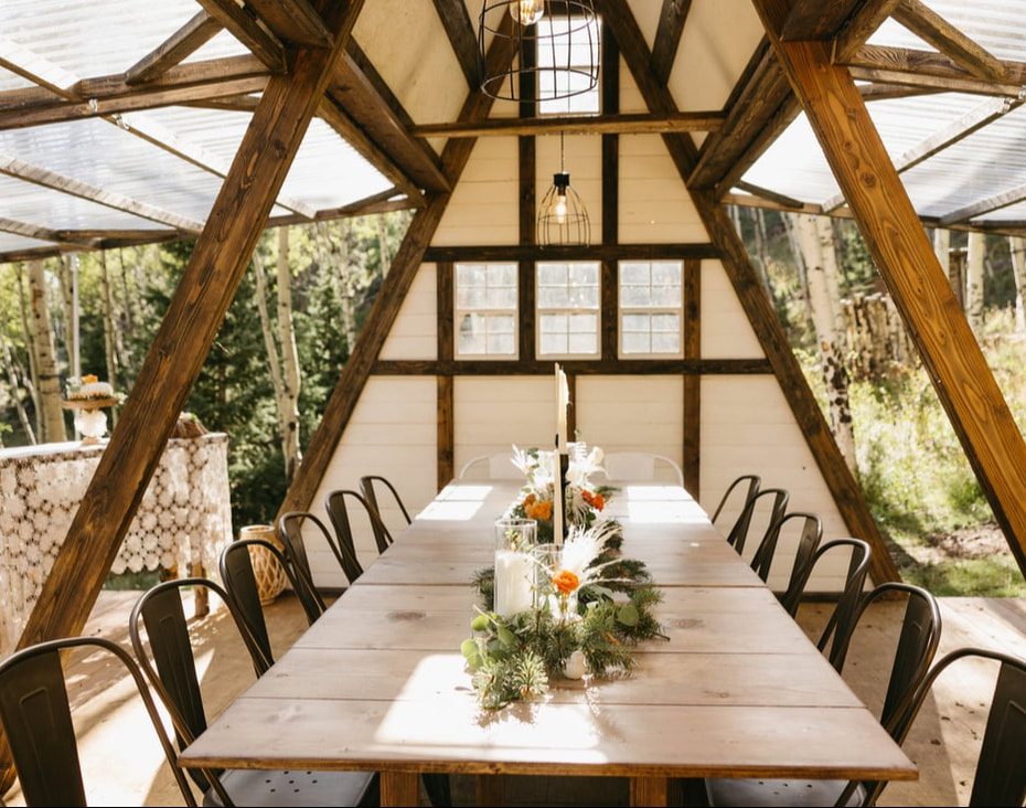 A-frame structure sits on a hill in the colorado forest, used for micro weddings and elopements